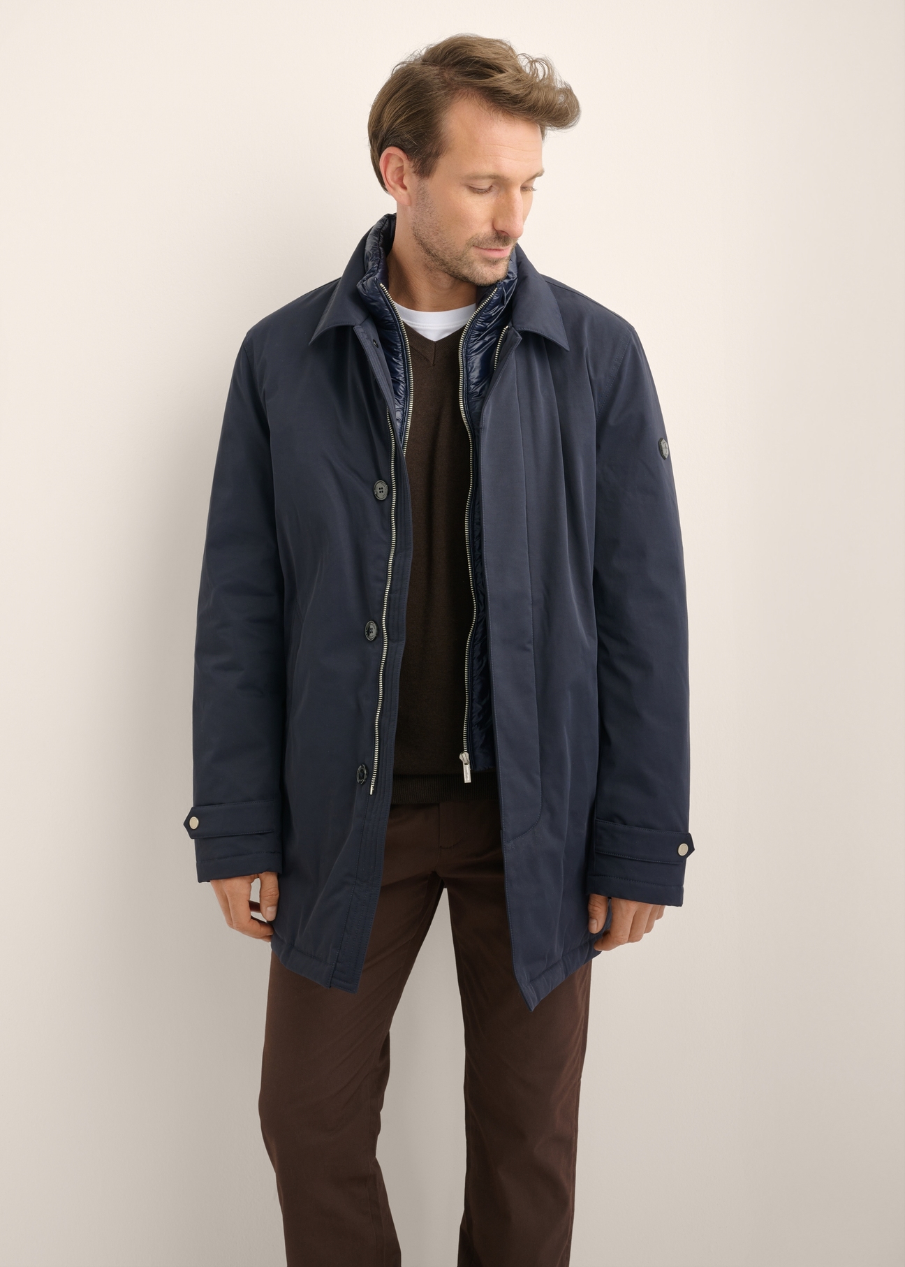 Dark navy men's winter jacket KURMT-0438-7E(Z26), front product view on model. Half silhouette visible.