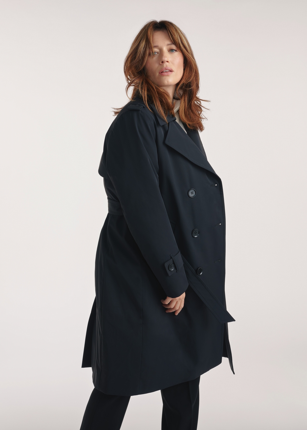 Black women's coat with insulation KURDT-0610-99(Z25), side view of the product on the model, half of the silhouette visible.