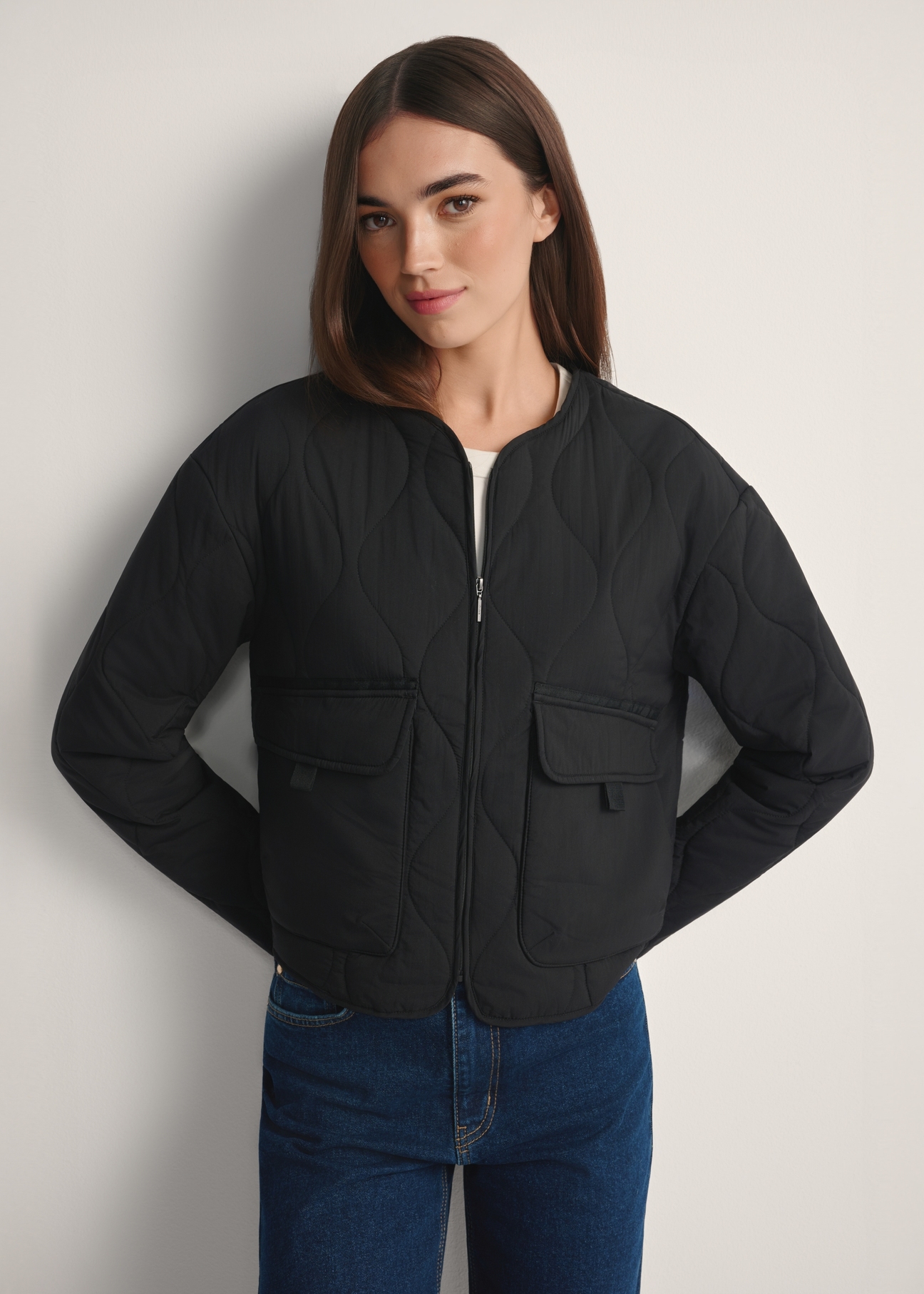 Black women's transitional nylon jacket KURDT-0656-99(W26), front view of the product on the model, half of the silhouette visible.
