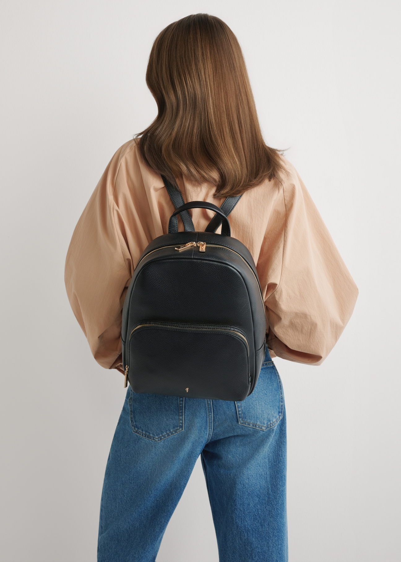 Women's leather backpack in black TORES-1276-9I(W26), front view of the product on the model's silhouette.