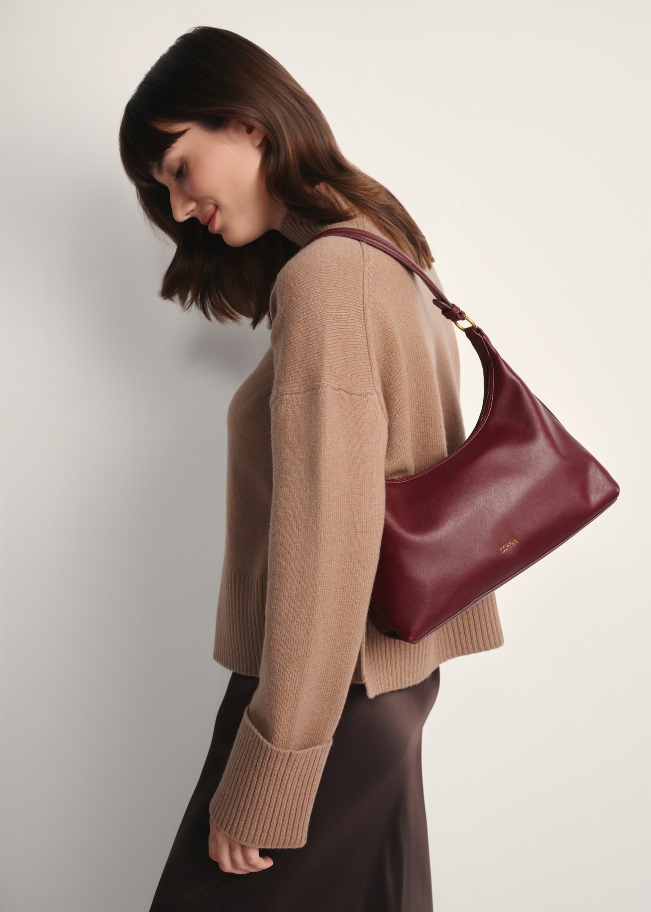 Burgundy women's handbag TOREC-1082-49(Z25), front view of the product on a model, half of the silhouette visible.