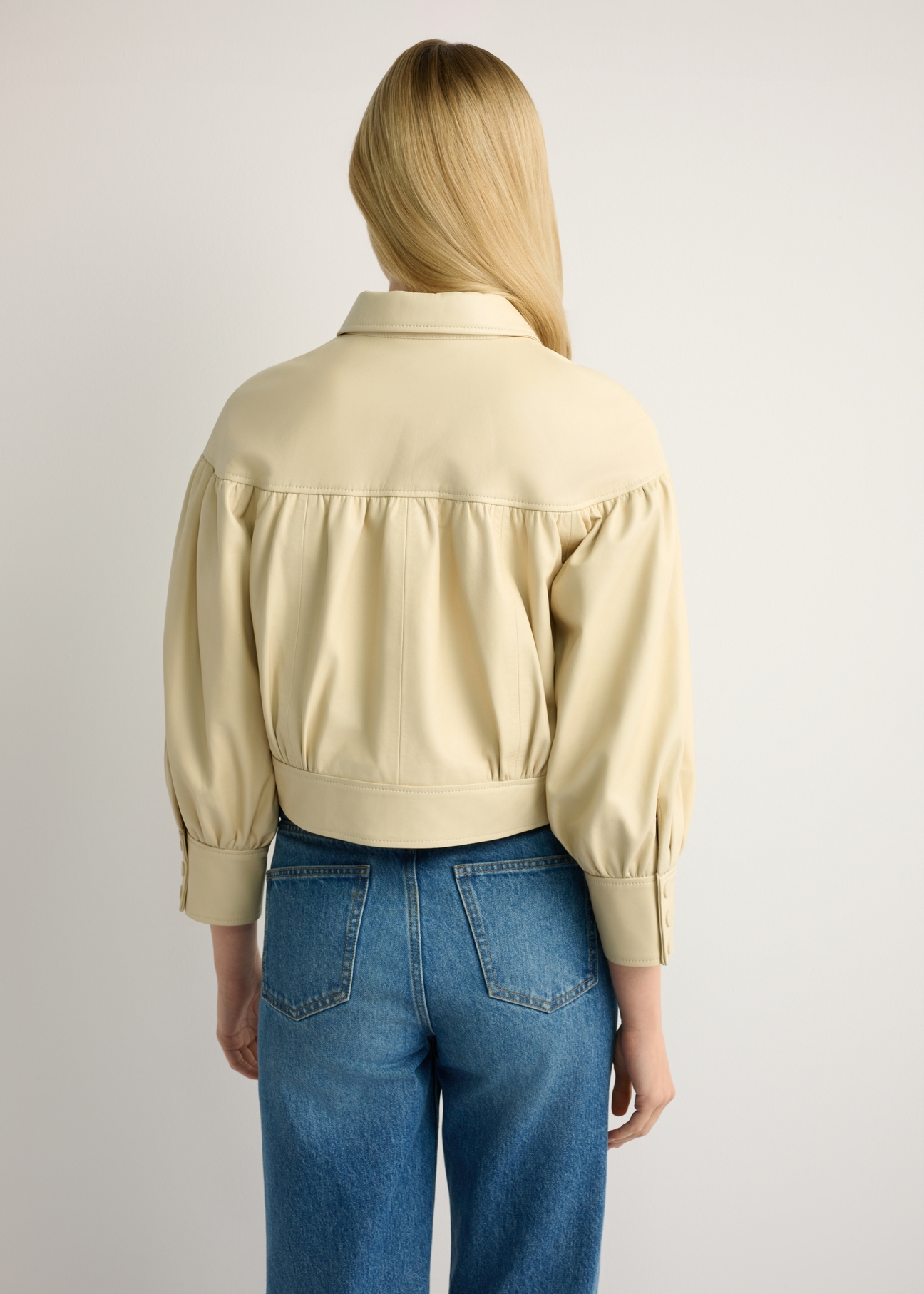 Light yellow women's leather jacket KURDS-0574-2A(W26), back view of the product on the model. Half of the silhouette visible.