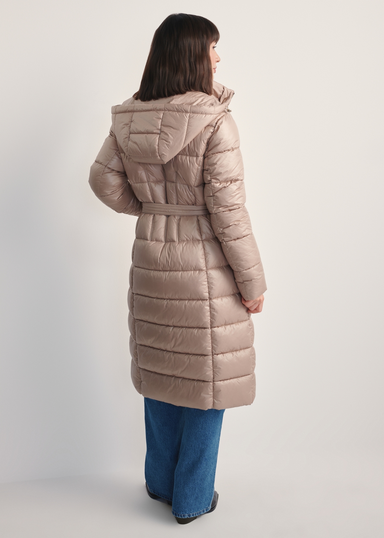 Beige women's long jacket KURDT-0603-82(Z25), back view of the product on the model. Full body visible.