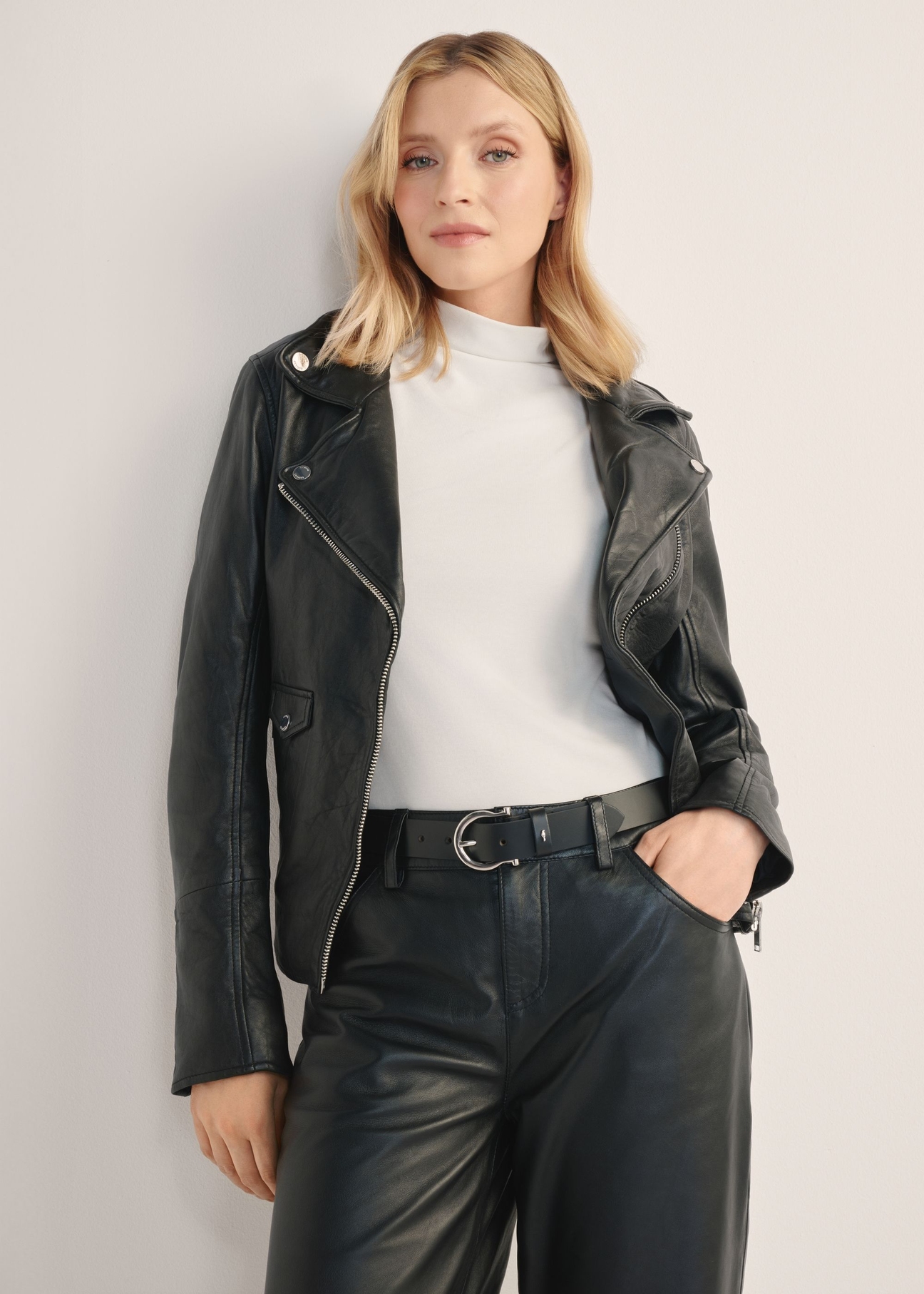 Women's black leather jacket KURDS-0184-99(KS), front view of the product on the model. Half of the silhouette visible.