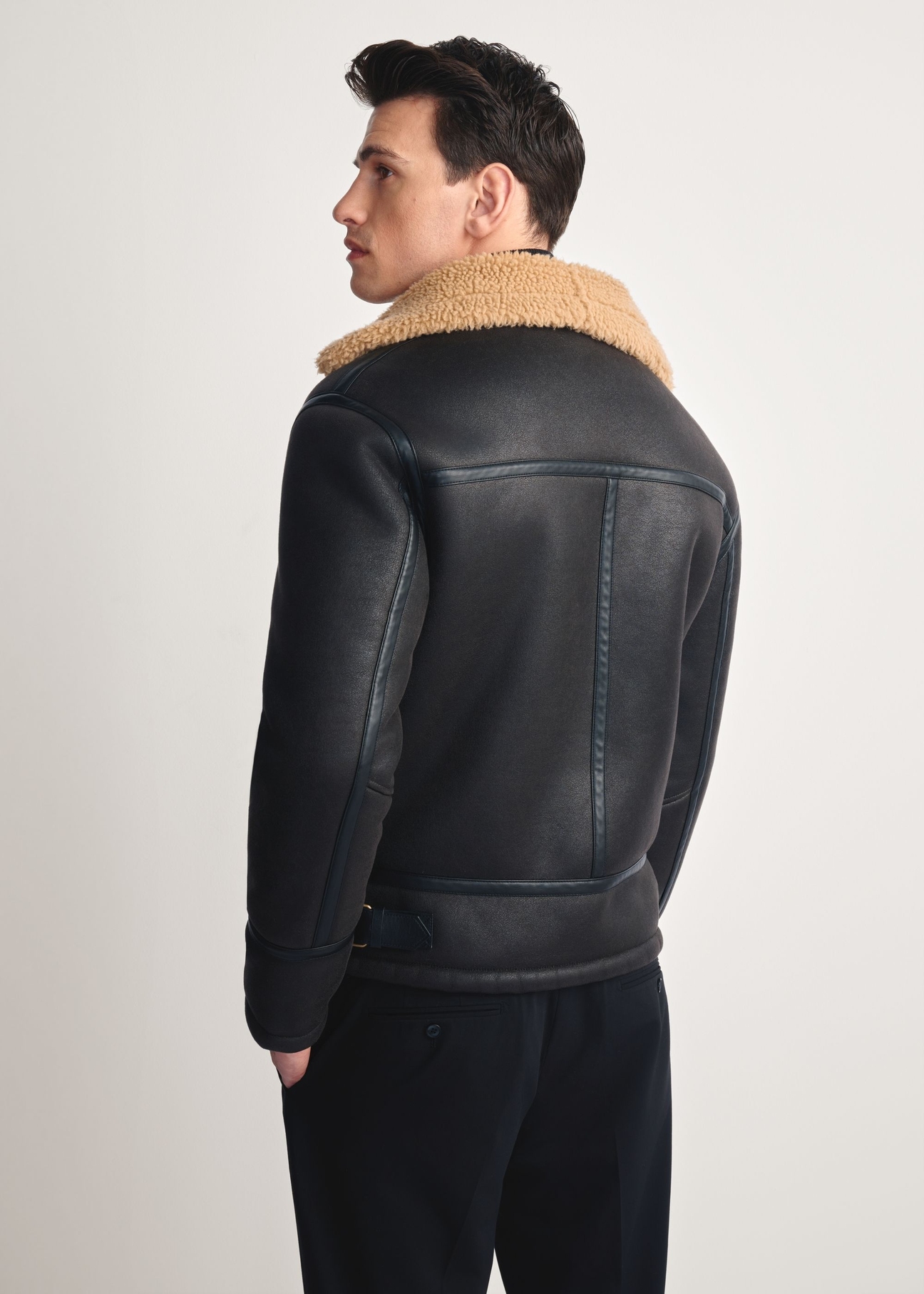 Dark brown men's sheepskin coat KOZMP-0002-1I(Z26), product view from the back on the model, half of the silhouette visible.