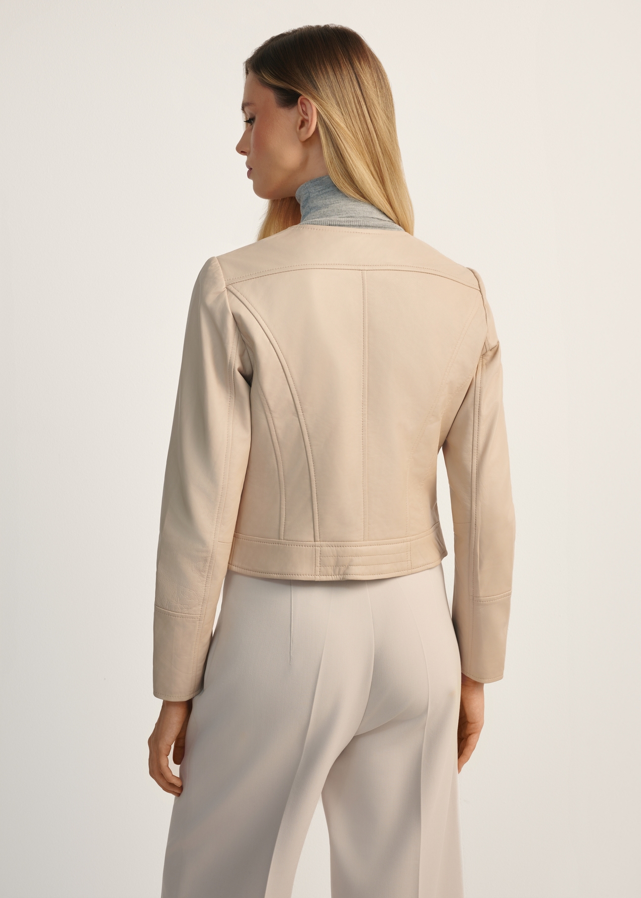 Beige women's leather biker jacket KURDS-0273-1365(KS), product view from the back on the model, half of the silhouette visible.