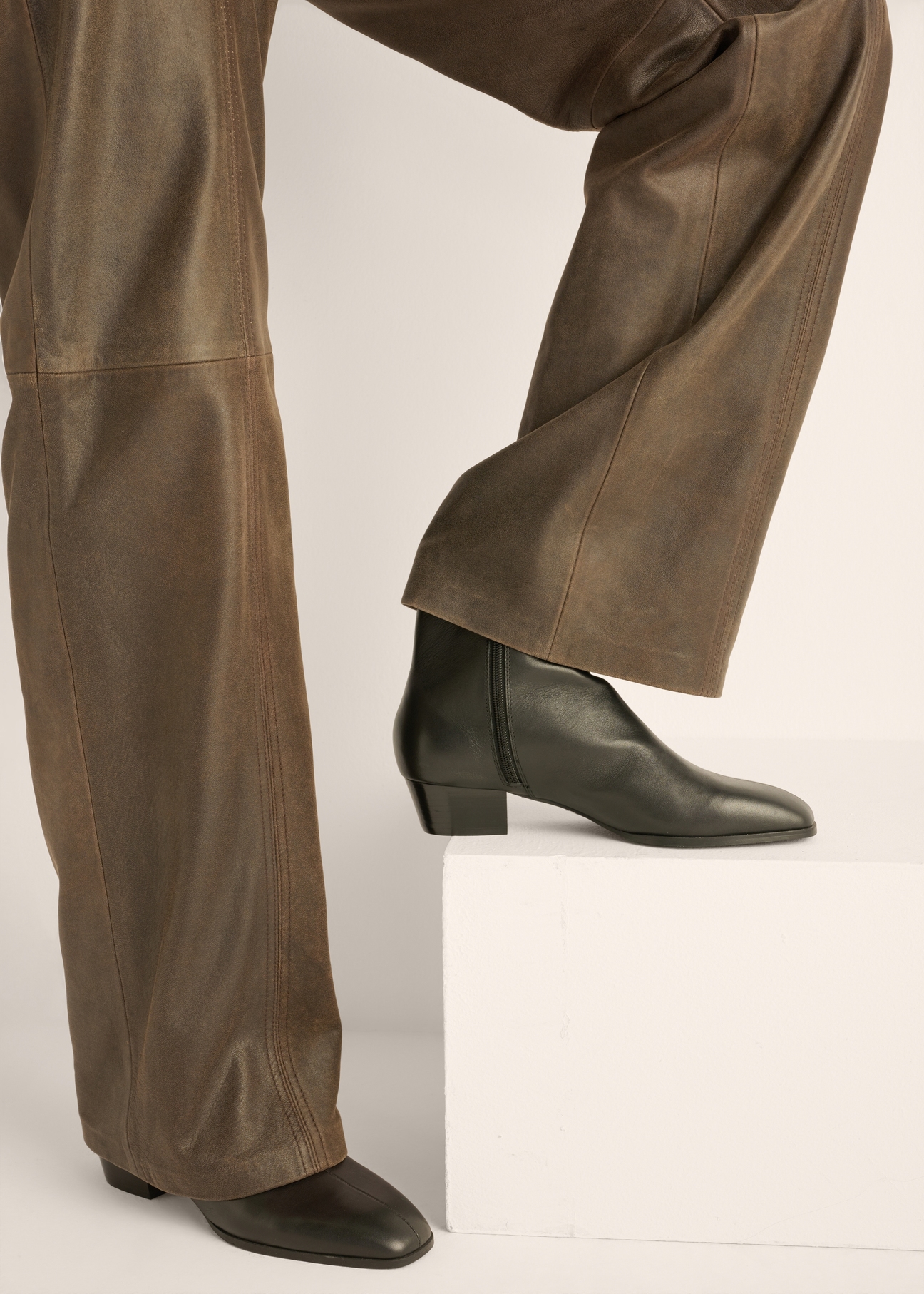 Women's black leather ankle boots BUTYD-1300-99(Z26), side view of the product on the model's feet.