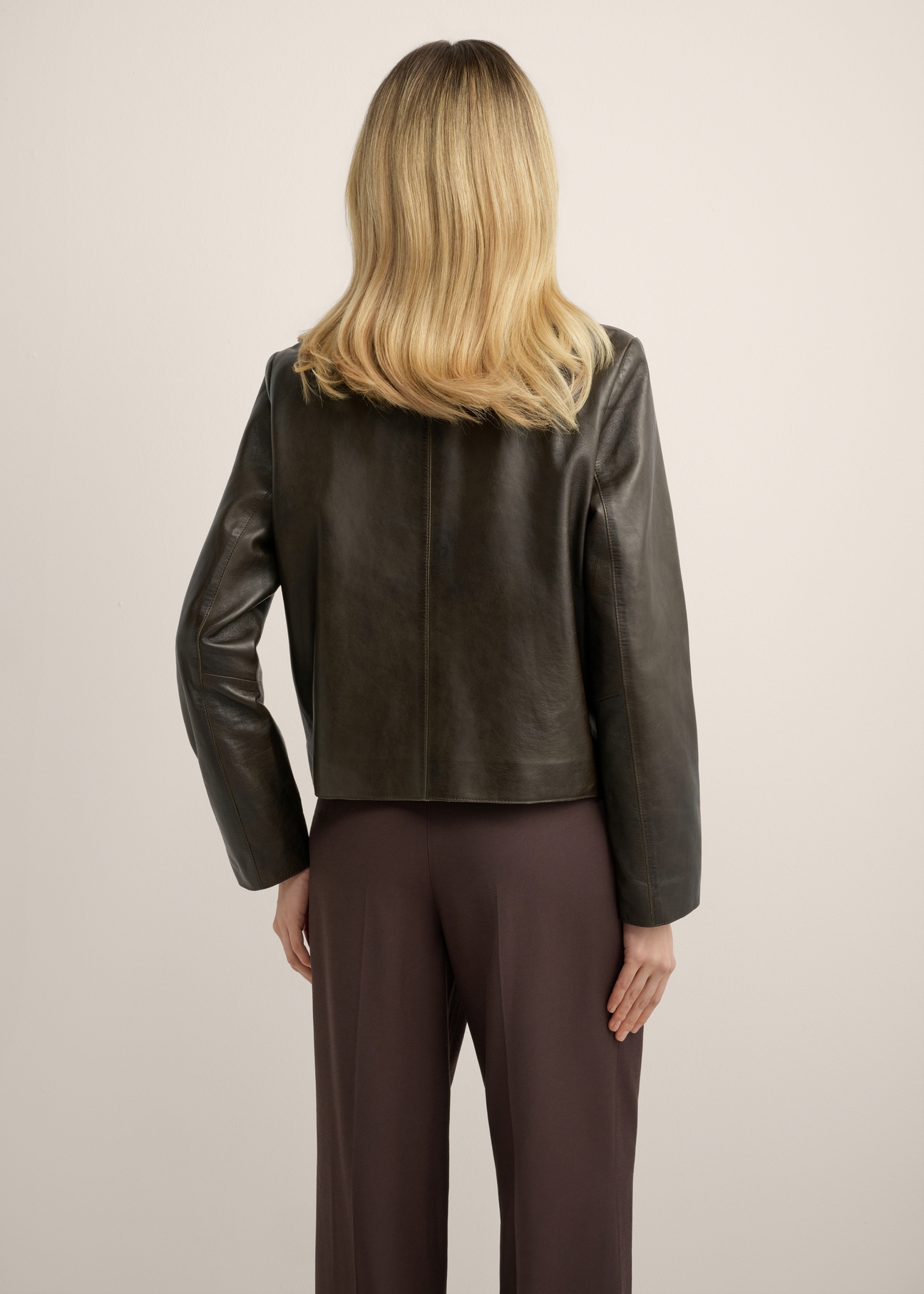 Women's brown leather short jacket KURDS-0552-1H(Z26), product view from the back on the model. Half of the silhouette visible.