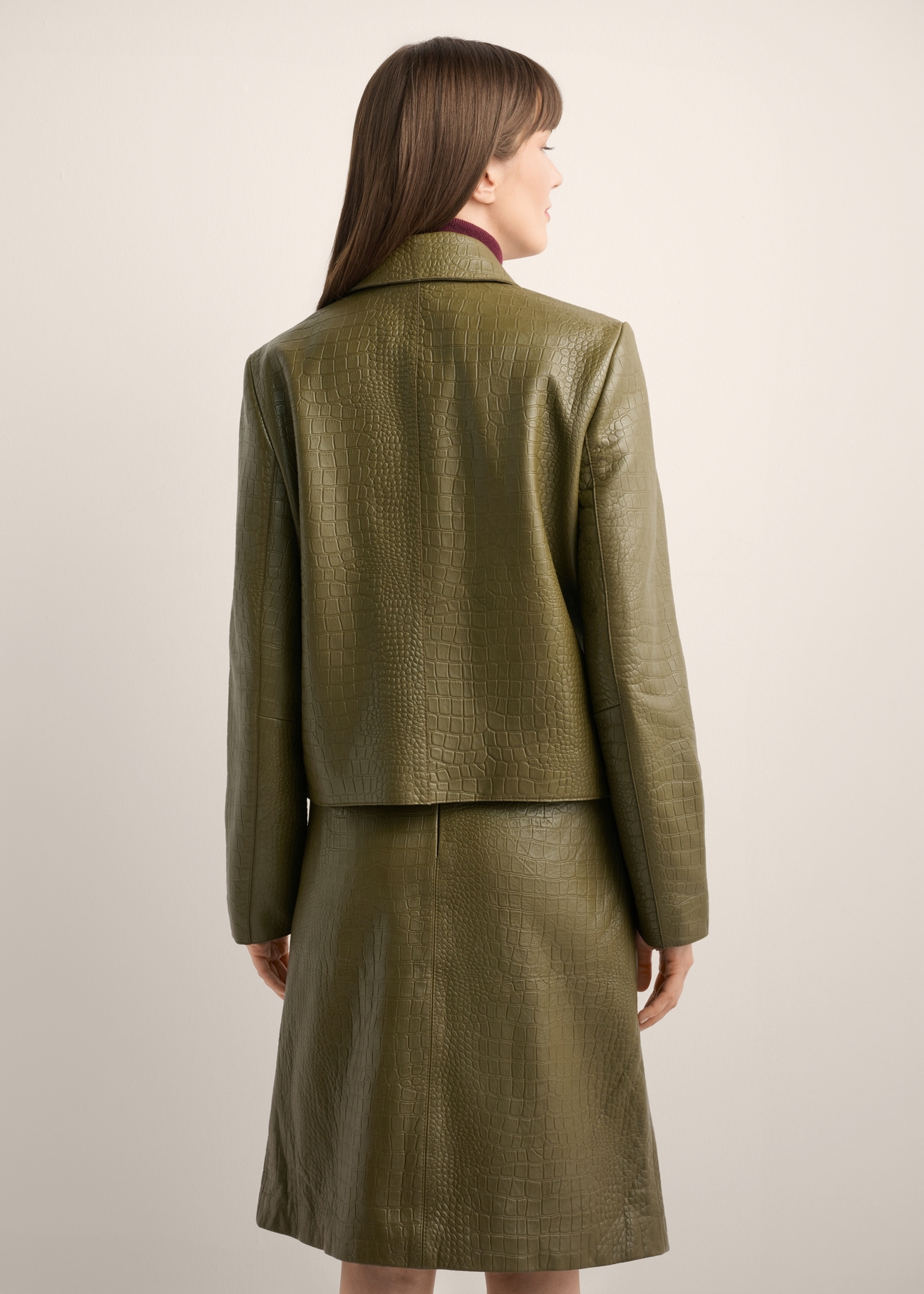 Women's olive green leather short jacket KURDS-0552-8E(Z26), back view of the product on the model. Half of the silhouette visible.