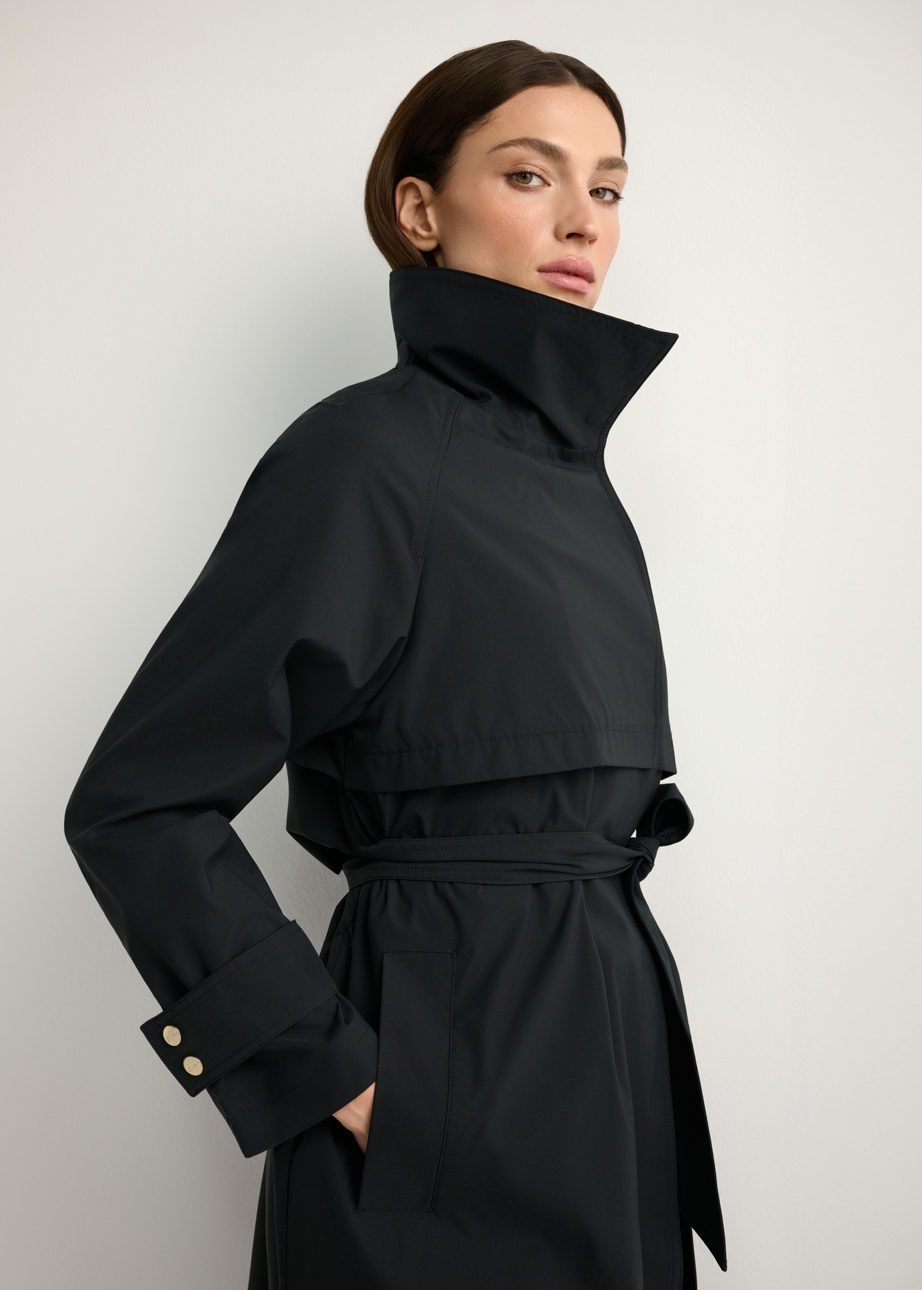 Black long women's coat KURDT-0653-99(W26), close-up of the product on the model's silhouette.