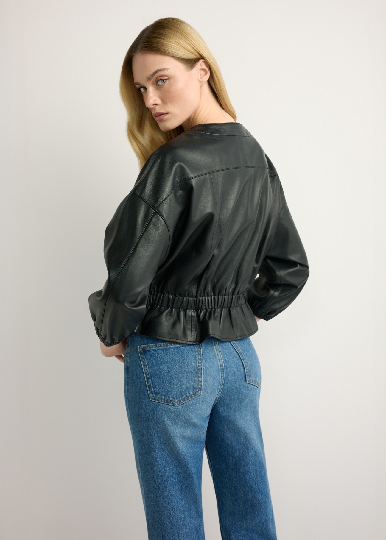 Women's black leather jacket KURDS-0570-99(W26), back view of the product on the model. Half of the silhouette visible.