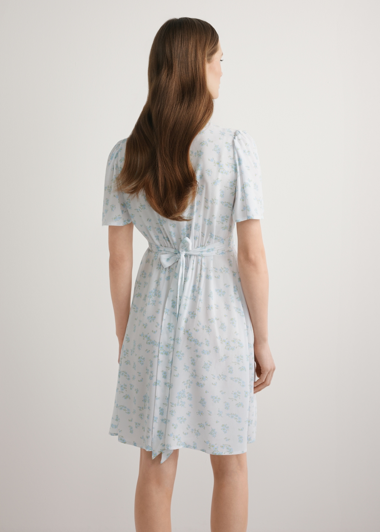 Women's short floral dress SUKDT-0276-7P(W26), back view of the product on the model. Half of the silhouette visible.