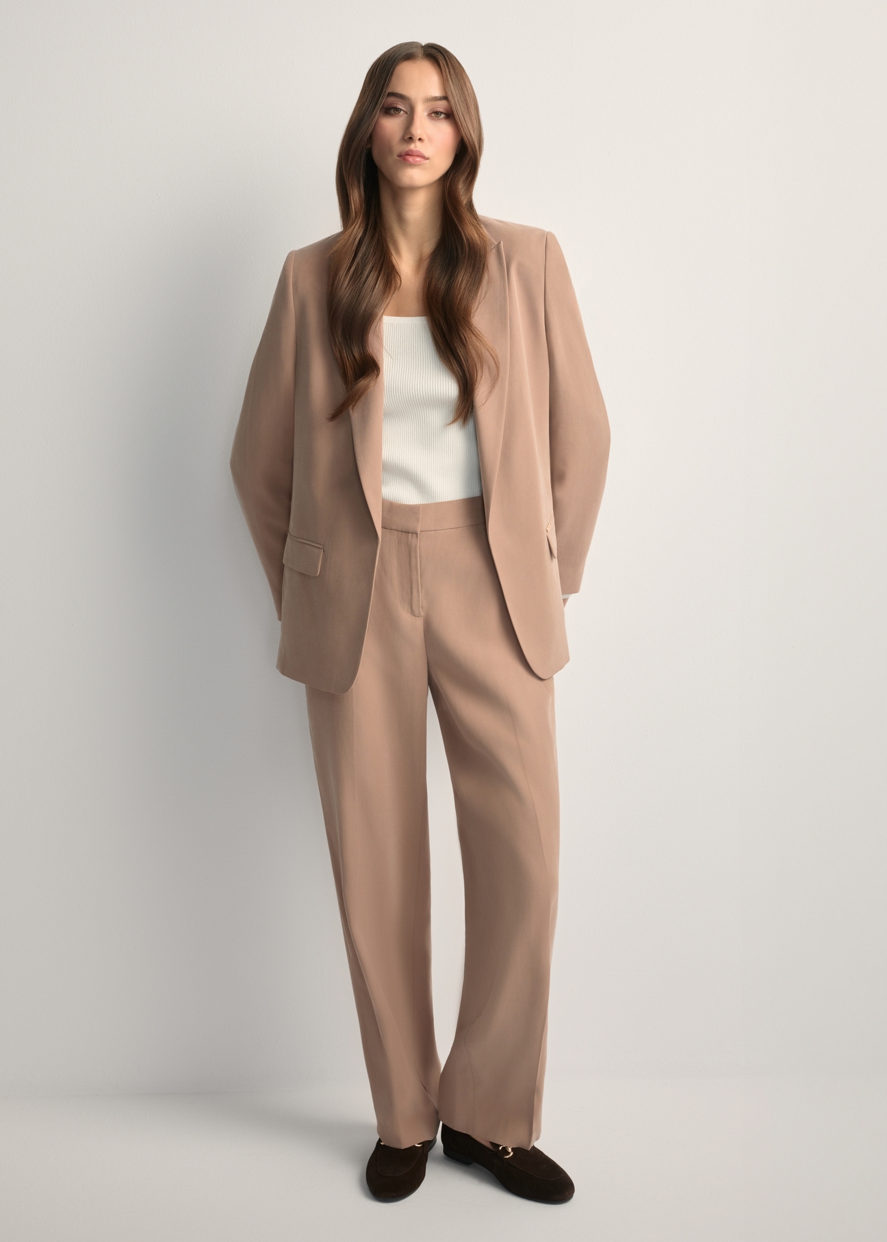 Beige elegant women's trousers SPODT-0106A-1D(W26), front view of the product on the model. Full body visible.