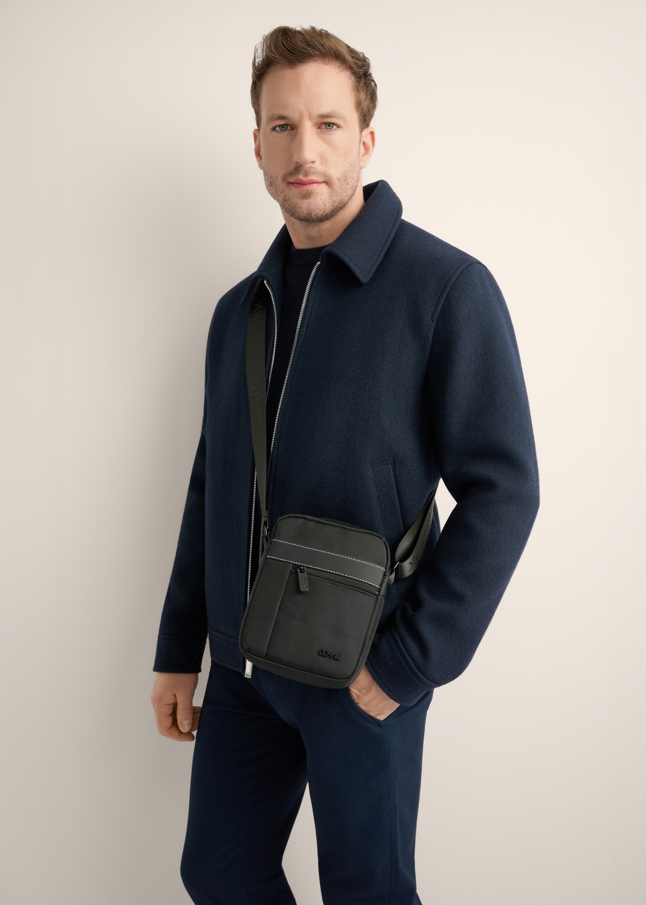 Men's city bag in black TORMN-0423-99(Z26), front view of the product on the model, half of the silhouette visible.
