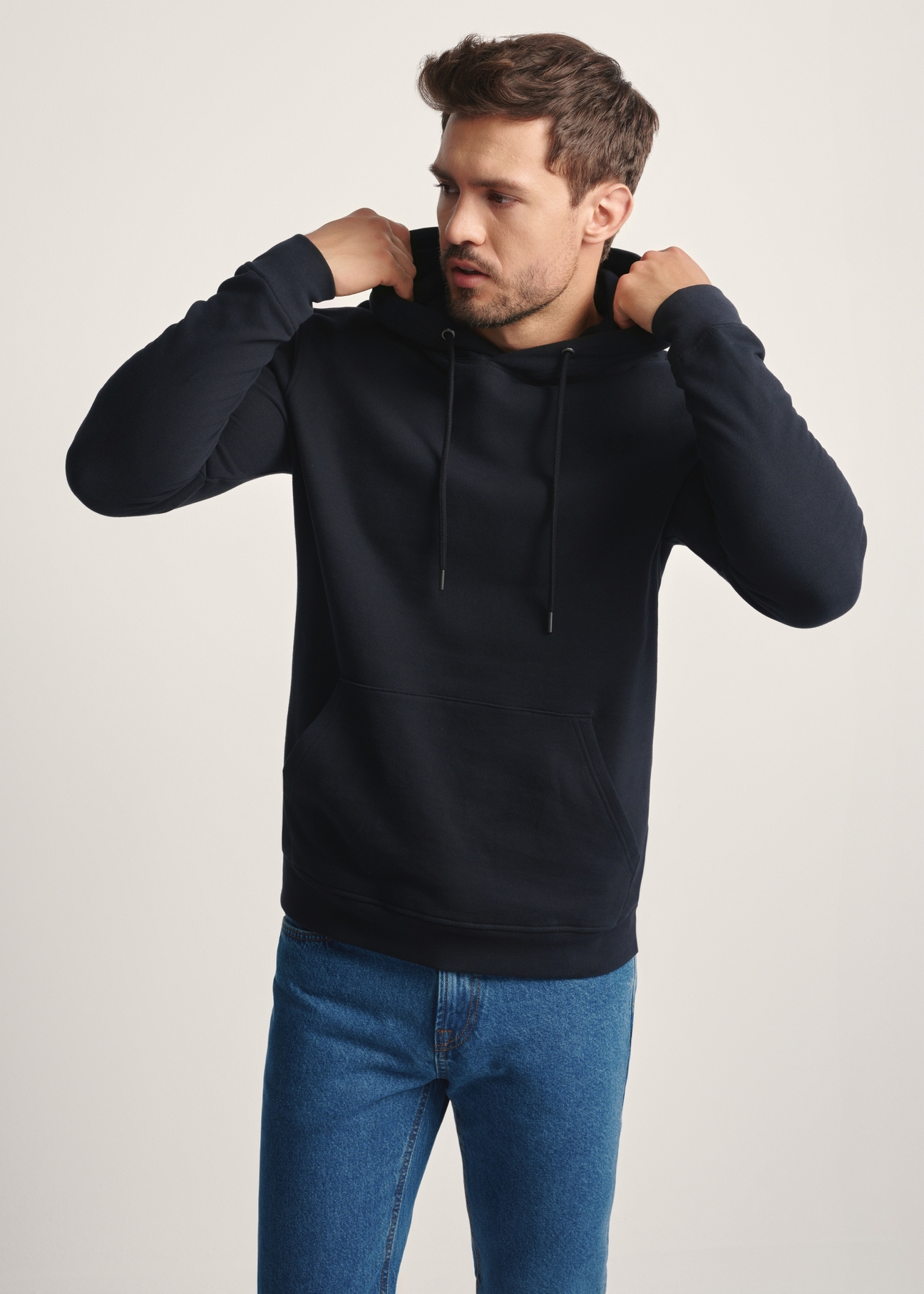 Men's black hoodie BLZMT-0073-99(Z25), front view of the product on the model. Half of the silhouette visible.