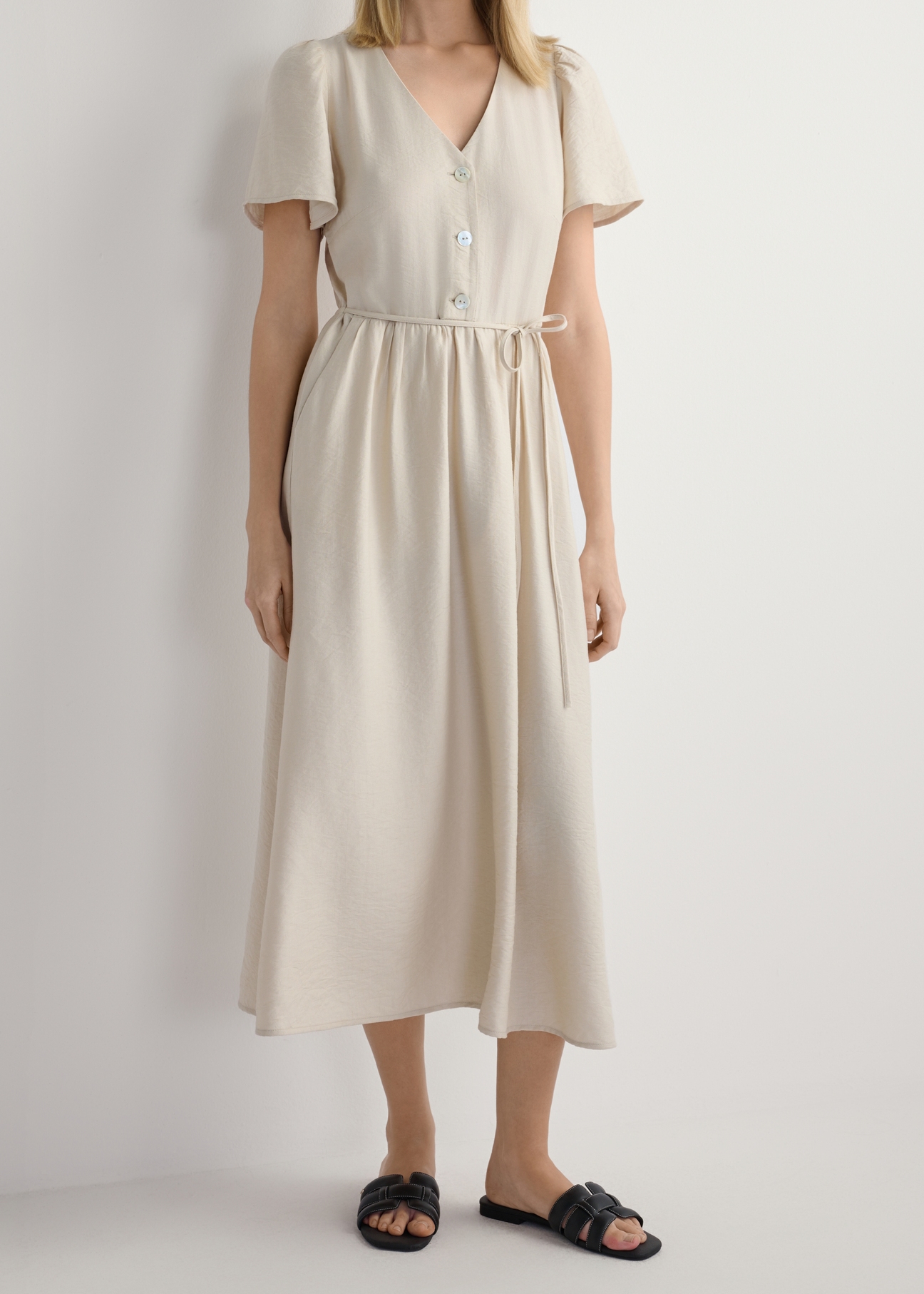 Women's black leather braided slides BUTYD-1225-99(W26), front view of the product on the model's feet, against a white background. Half of the silhouette visible.