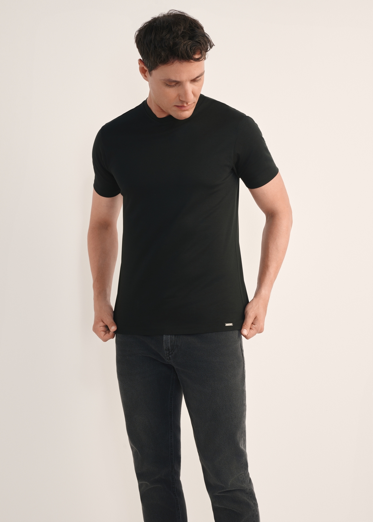 Men's black mercerized cotton T-shirt TSHMT-0135-99(Z25), front view of the product on the model. Half of the silhouette visible.