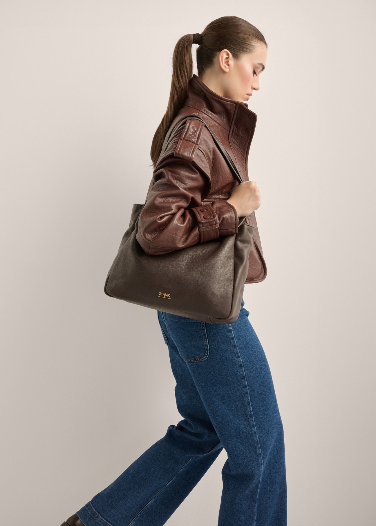 Women's brown leather shoulder bag TORES-1376-1H(Z26), front view of the product on a model. Half of the silhouette visible.