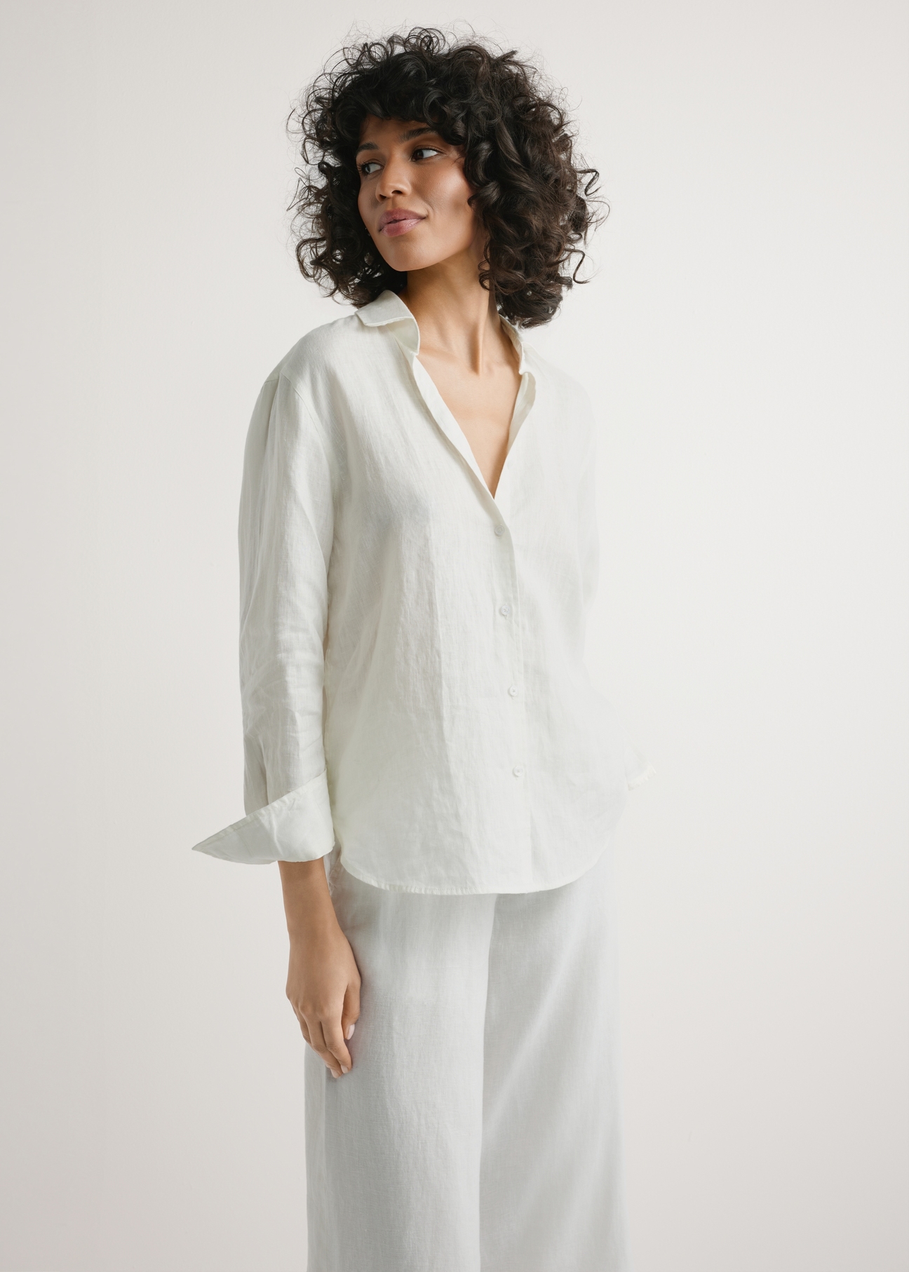 Women's white linen shirt KOSDT-0163A-0B(W26) - front view of the product, on a model, against a light background. Half of the silhouette visible.