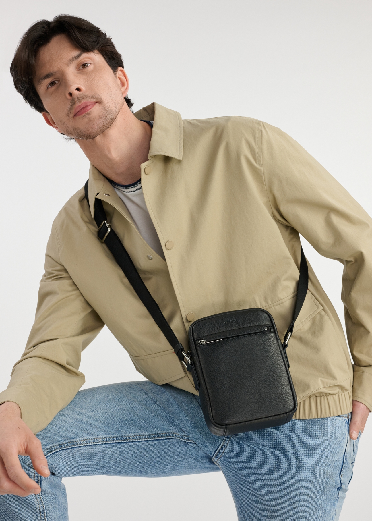 Leather black men's bag TORMS-0451-99(W25), front view of the product on the model. Half of the silhouette visible.