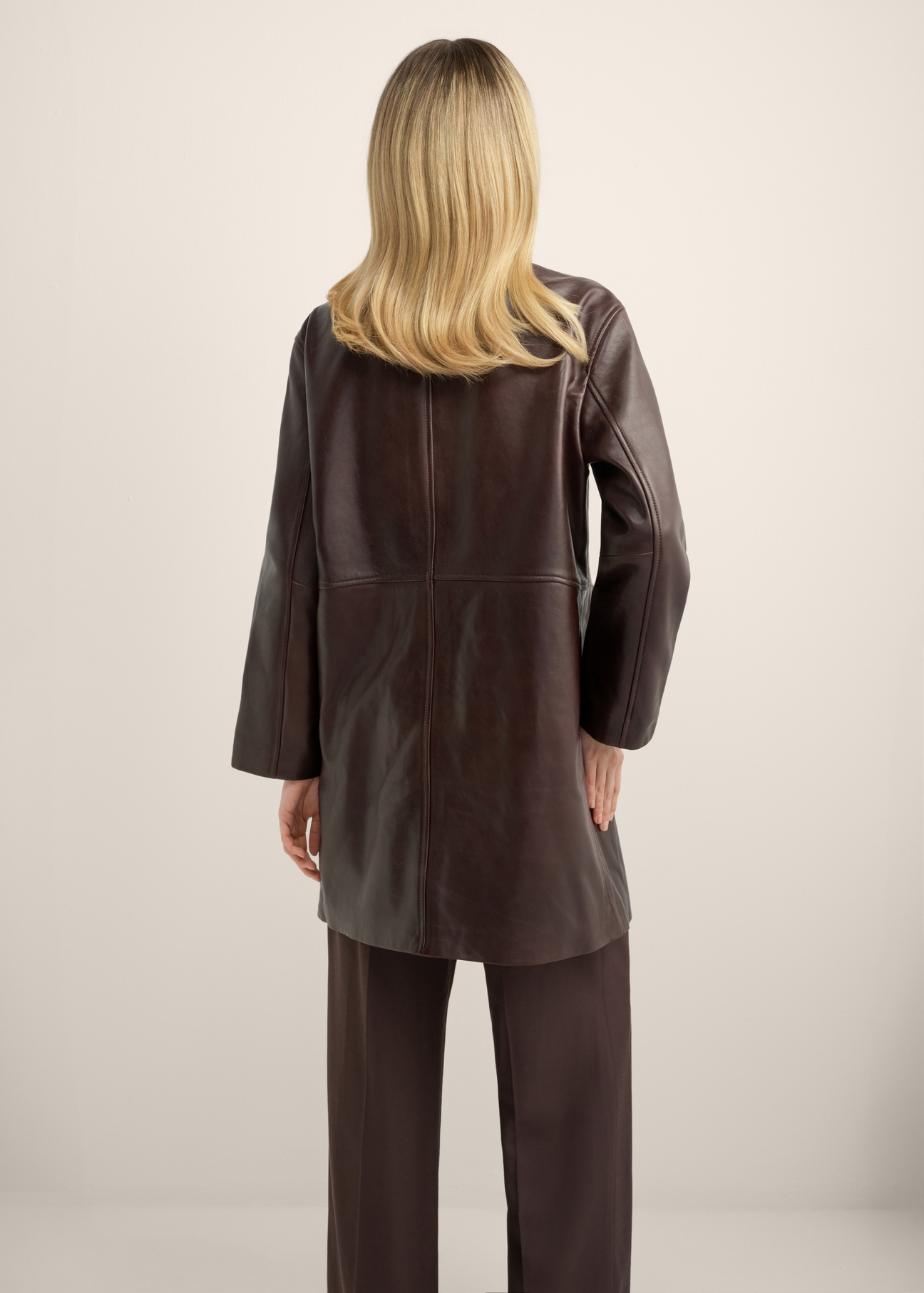 Women's brown leather coat KURDS-0649-1H(Z26), back view of the product on the model. Half of the silhouette visible.