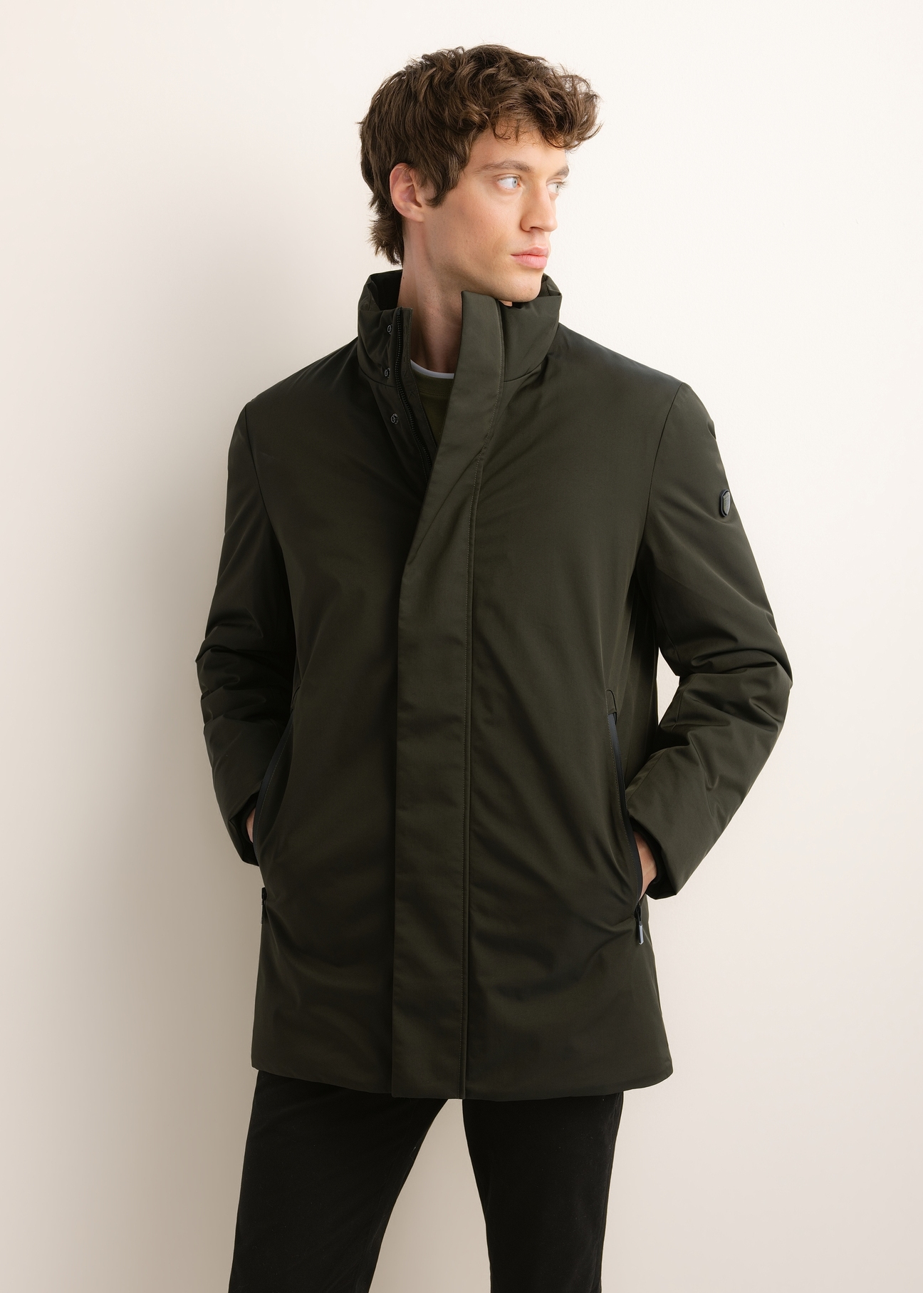 Green men's long winter jacket KURMT-0432-8B(Z26), front product view on model. Half silhouette visible.