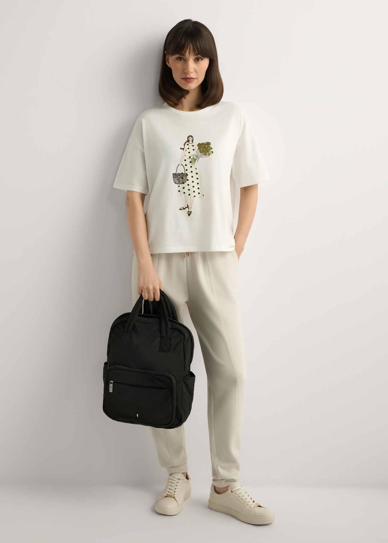 Black nylon women's backpack TOREN-0341-99(W26), product view in model's hand. Full body visible.