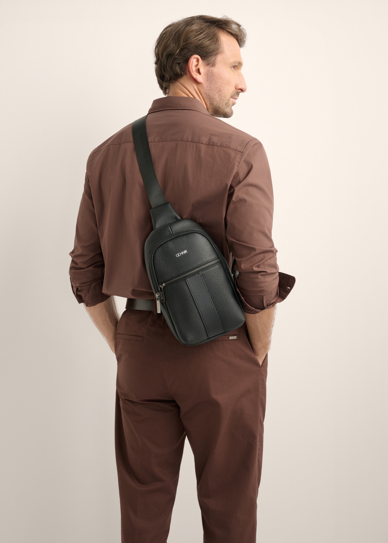 Black men's leather crossbody bag TORMS-0538-9I(Z26), front view of the product on the model. Half of the silhouette visible.