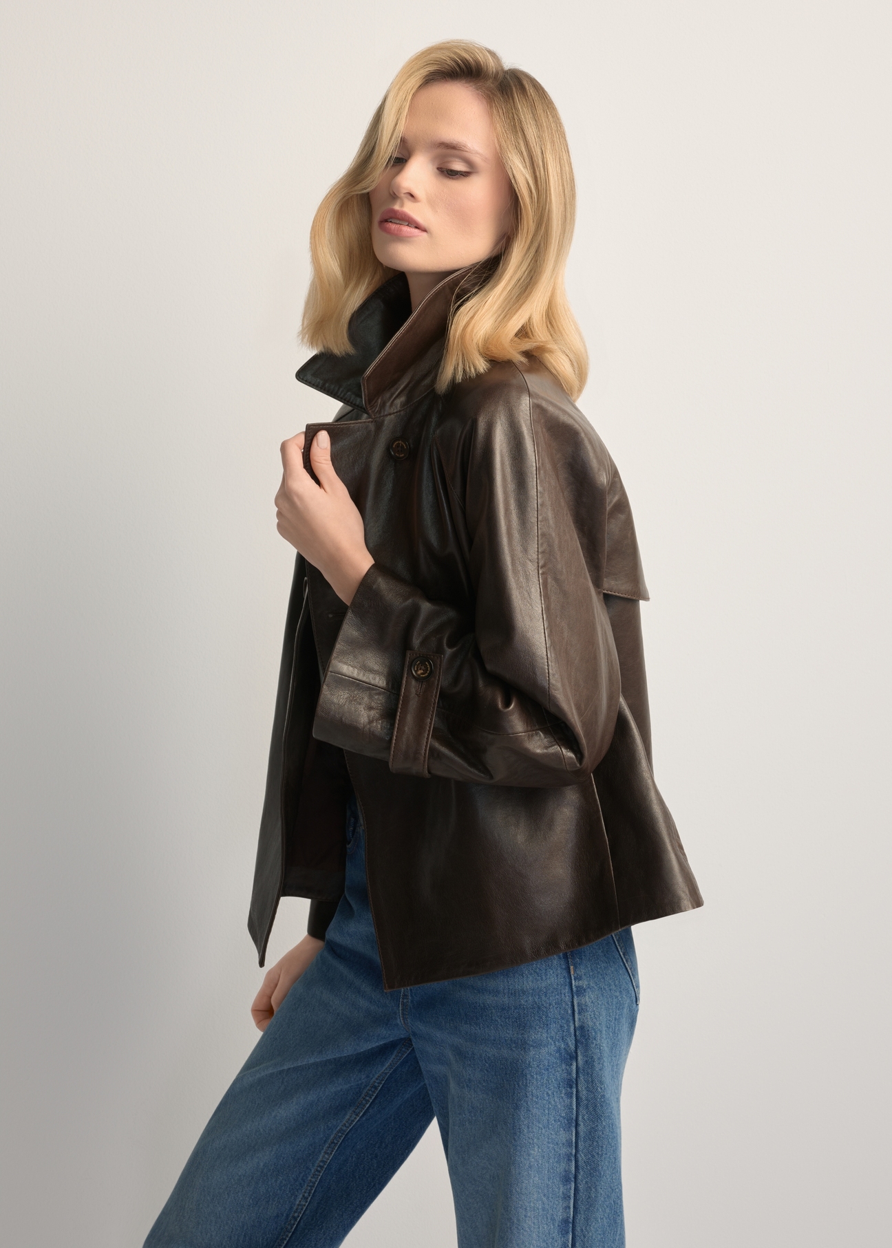 Women's dark brown leather jacket KURDS-0604-1I(W26), side view of the product on the model. Half of the silhouette visible.