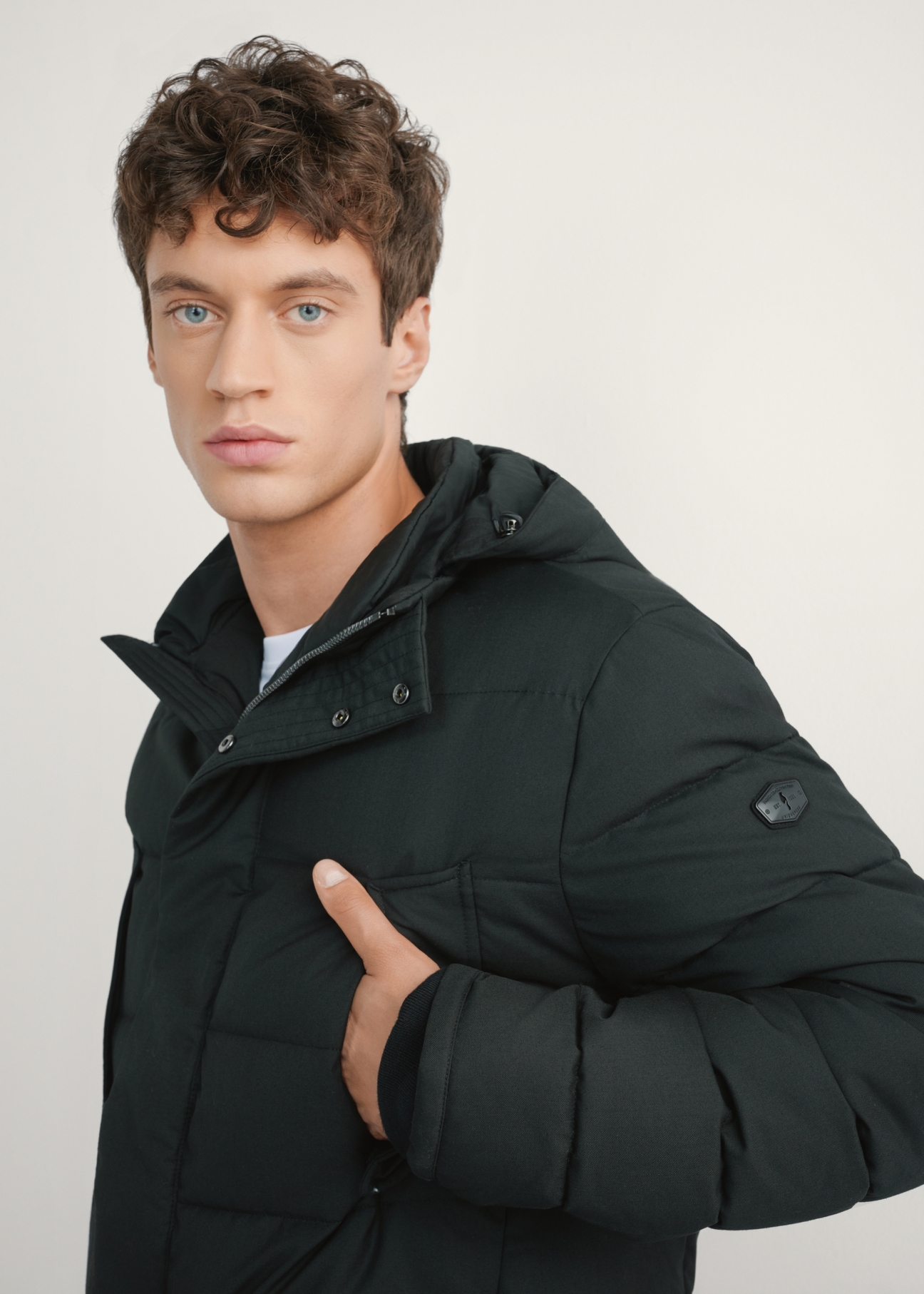 Black men's winter jacket KURMT-0379-99(Z25), close-up of the product detail on the model's silhouette.