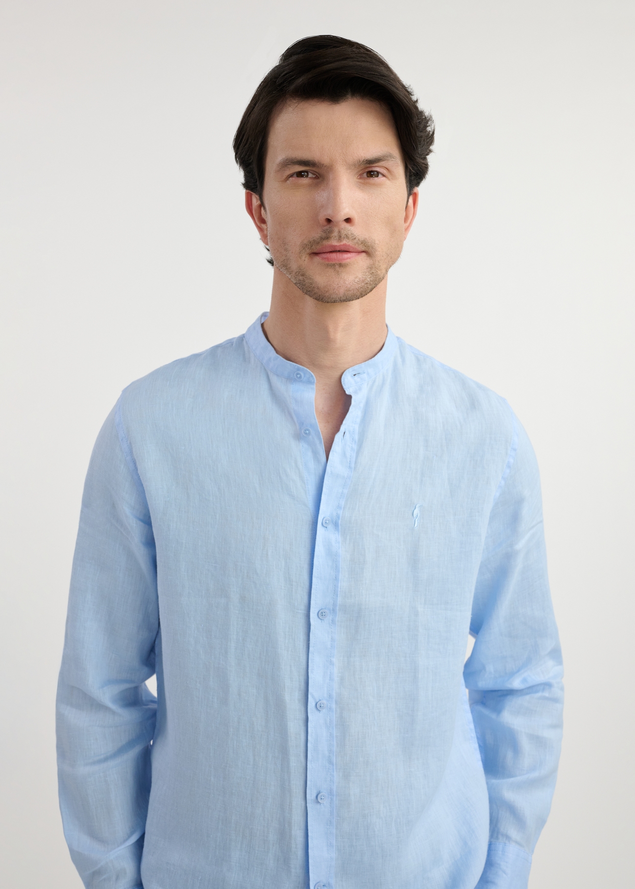 Light blue linen men's shirt KOSMT-0337-60(W25) - close-up front view on model on white background. Half of the silhouette visible.