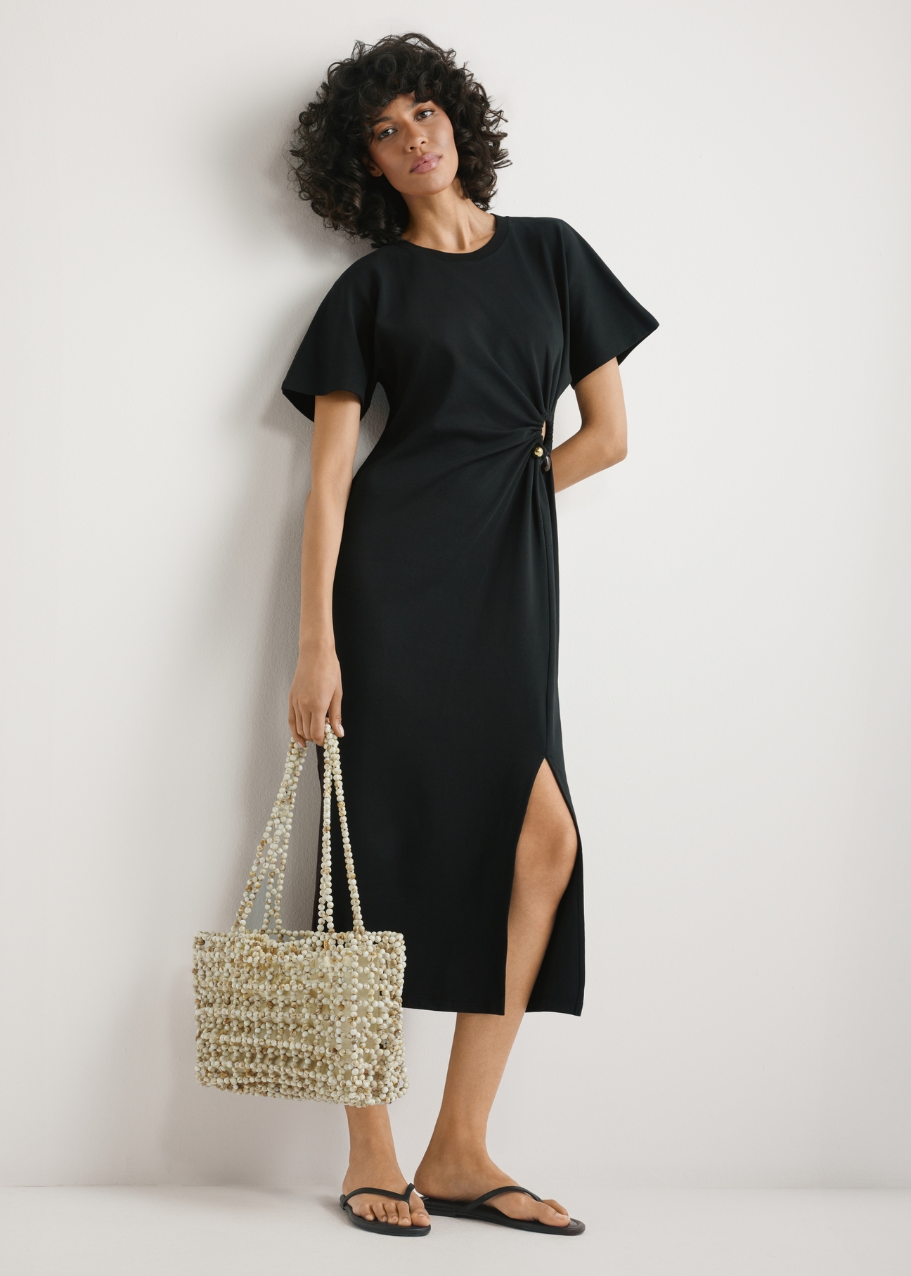 Women's beaded handbag TOREC-1144-0C(W26) - view of the product held in the model's hand, against a light background. The entire silhouette is visible.