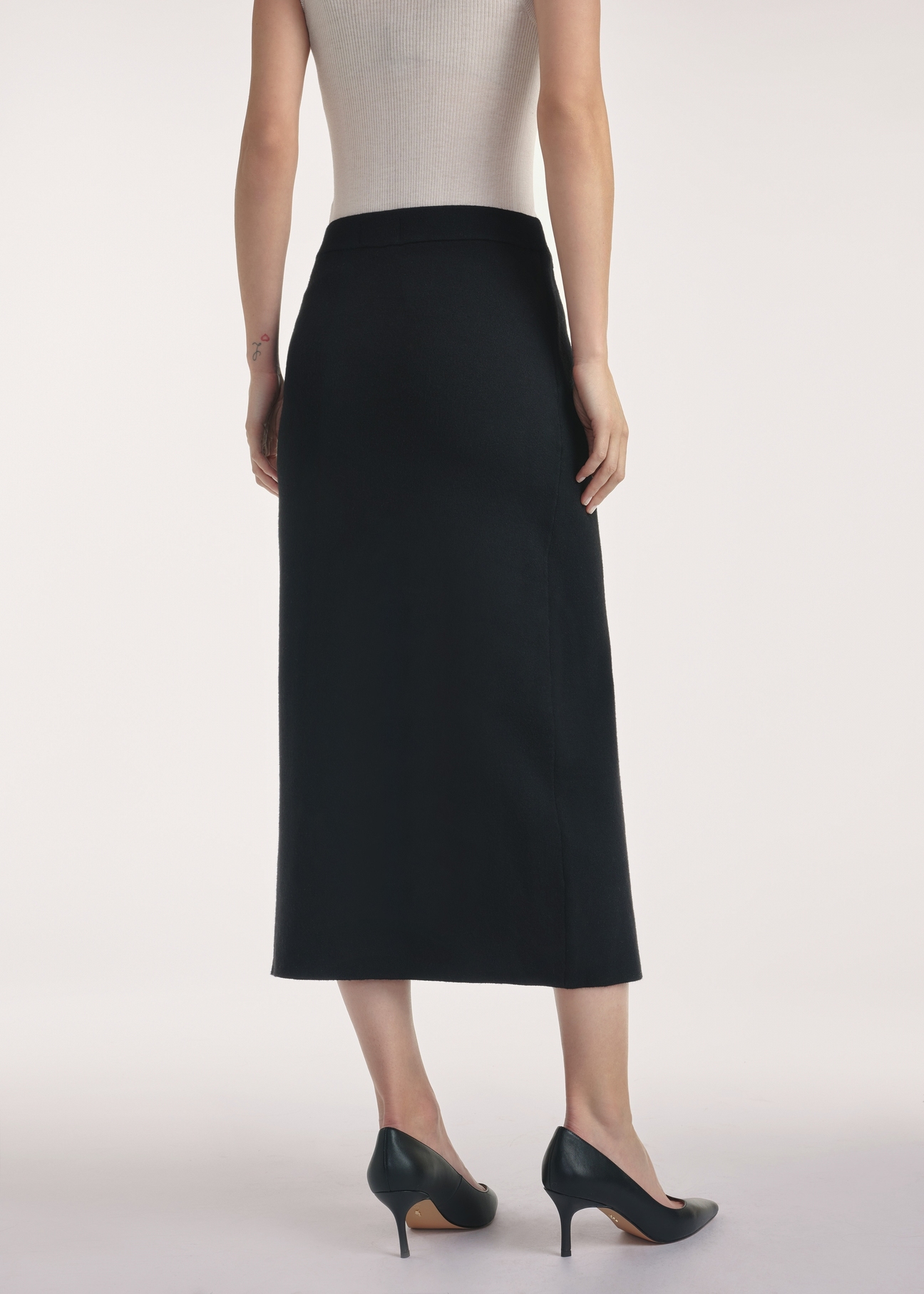 Black midi skirt SPCDT-0114-99(Z25), product view from the back on the model, half of the silhouette visible.