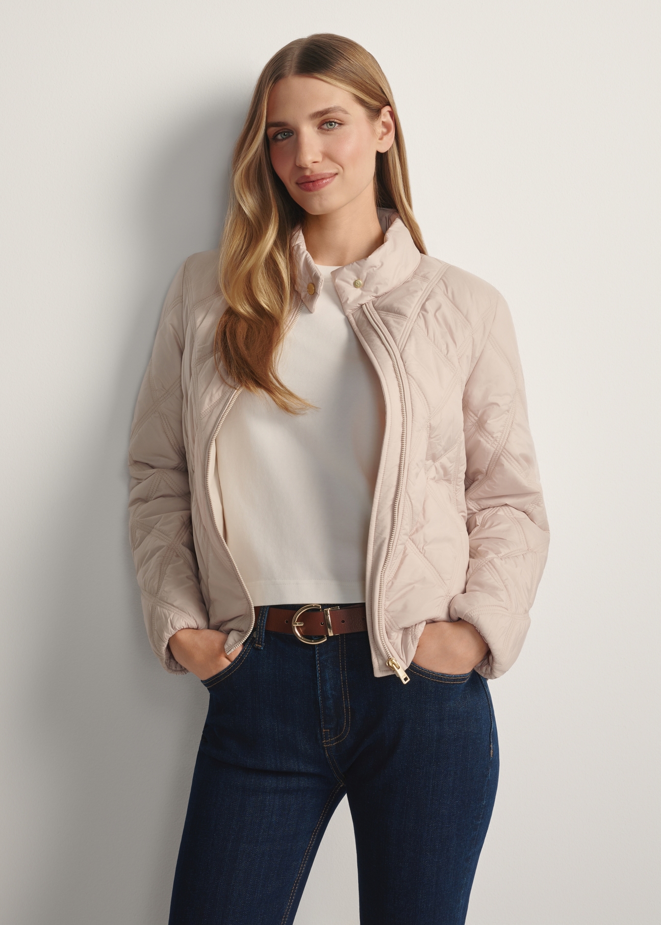 Beige women's quilted jacket KURDT-0658-1A(W26), front view of the unbuttoned product on the model. Half of the silhouette visible.