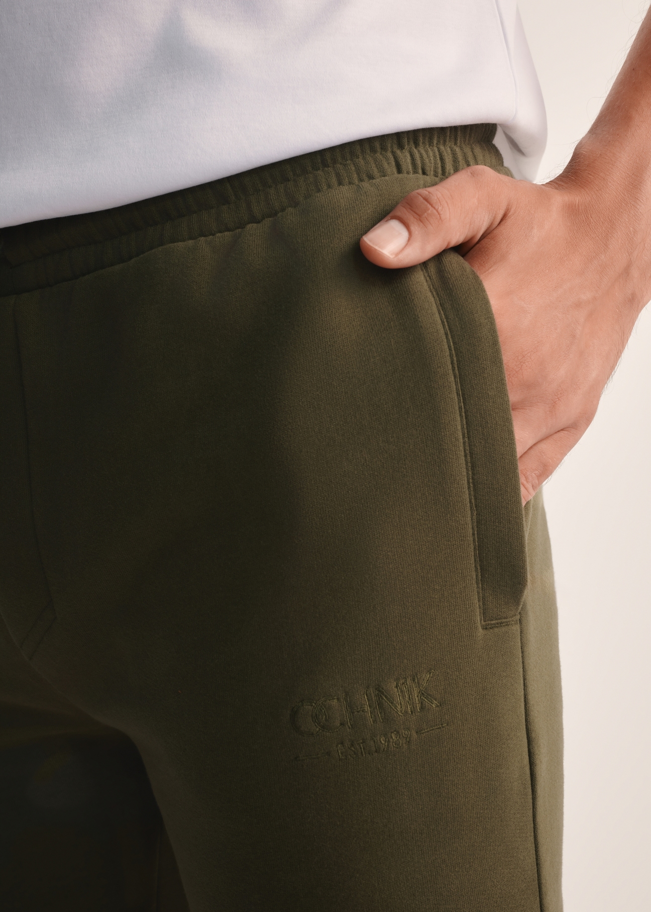 Men's khaki sweatpants SPOMT-0101-55(Z25), close-up of the product detail on the model.