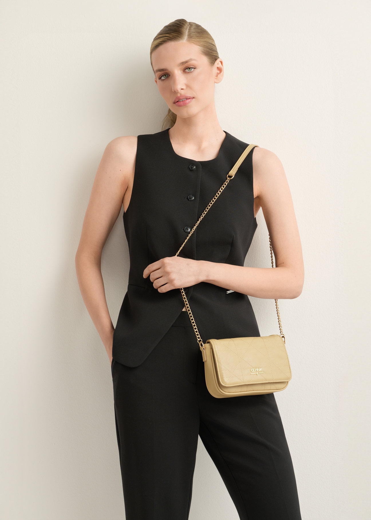 Beige small messenger bag TOREC-1254-1P(Z26), diagonal view of the product on the model. Half of the silhouette visible.