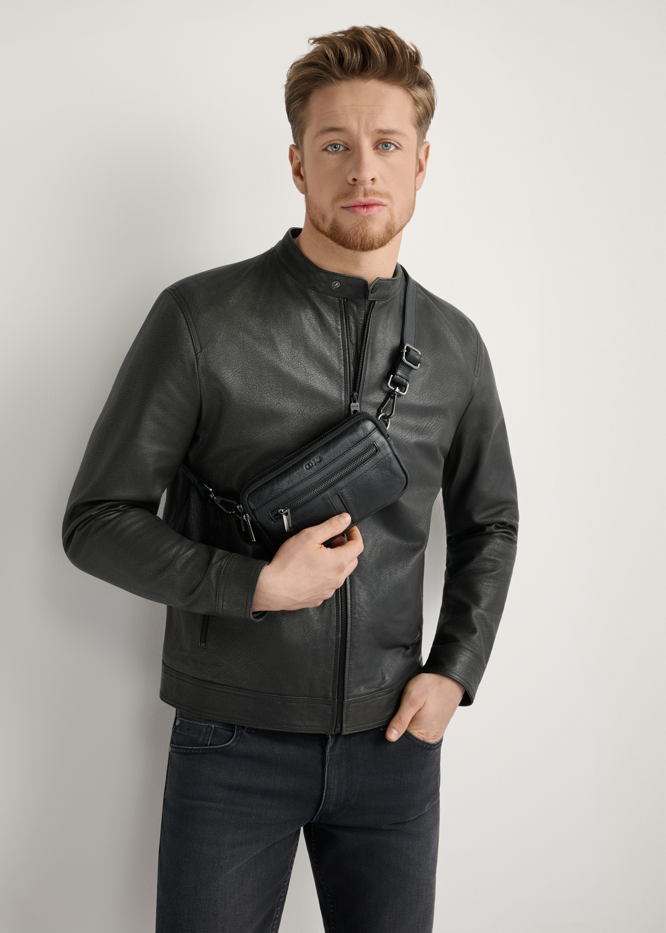 Small black leather men's bag TORMS-0492-99(W26), front view of the product on the model, the entire silhouette is visible.