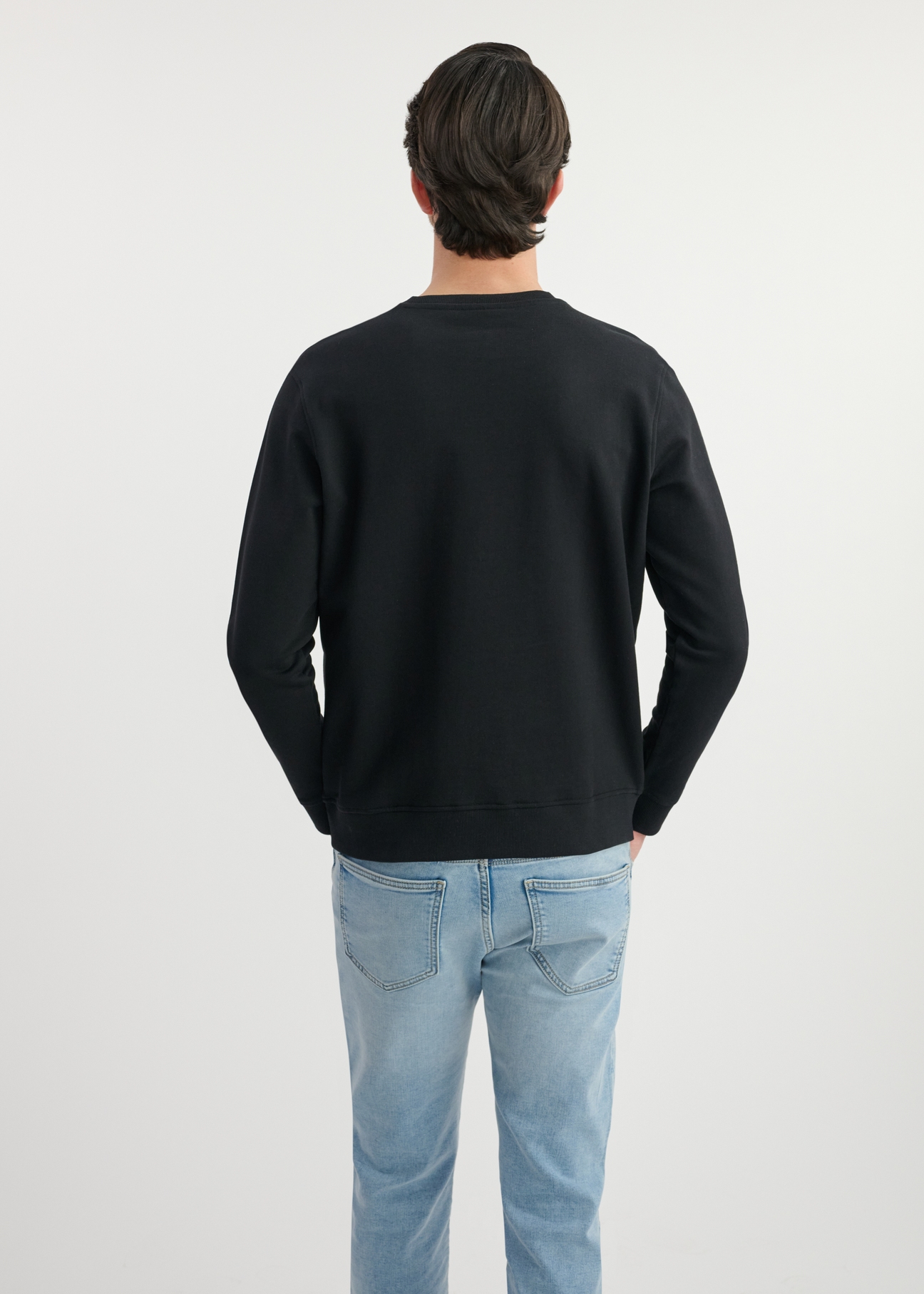Black men's sweatshirt without hood BLZMT-0070-99(W25) - back view on the model on a white background. Half of the silhouette visible.