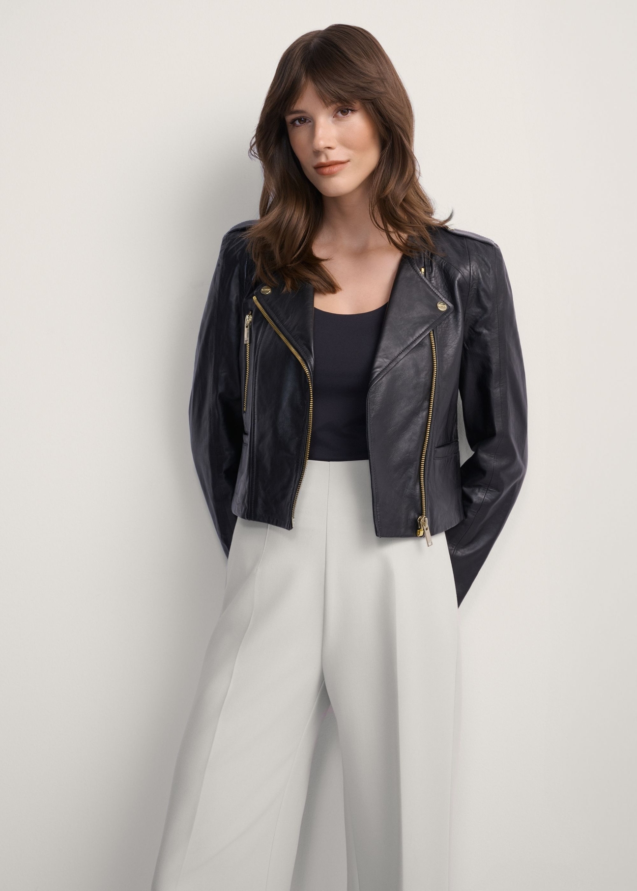 Women's black leather biker jacket KURDS-0323A-99(KS), front view of the product on the model. Half of the silhouette visible.