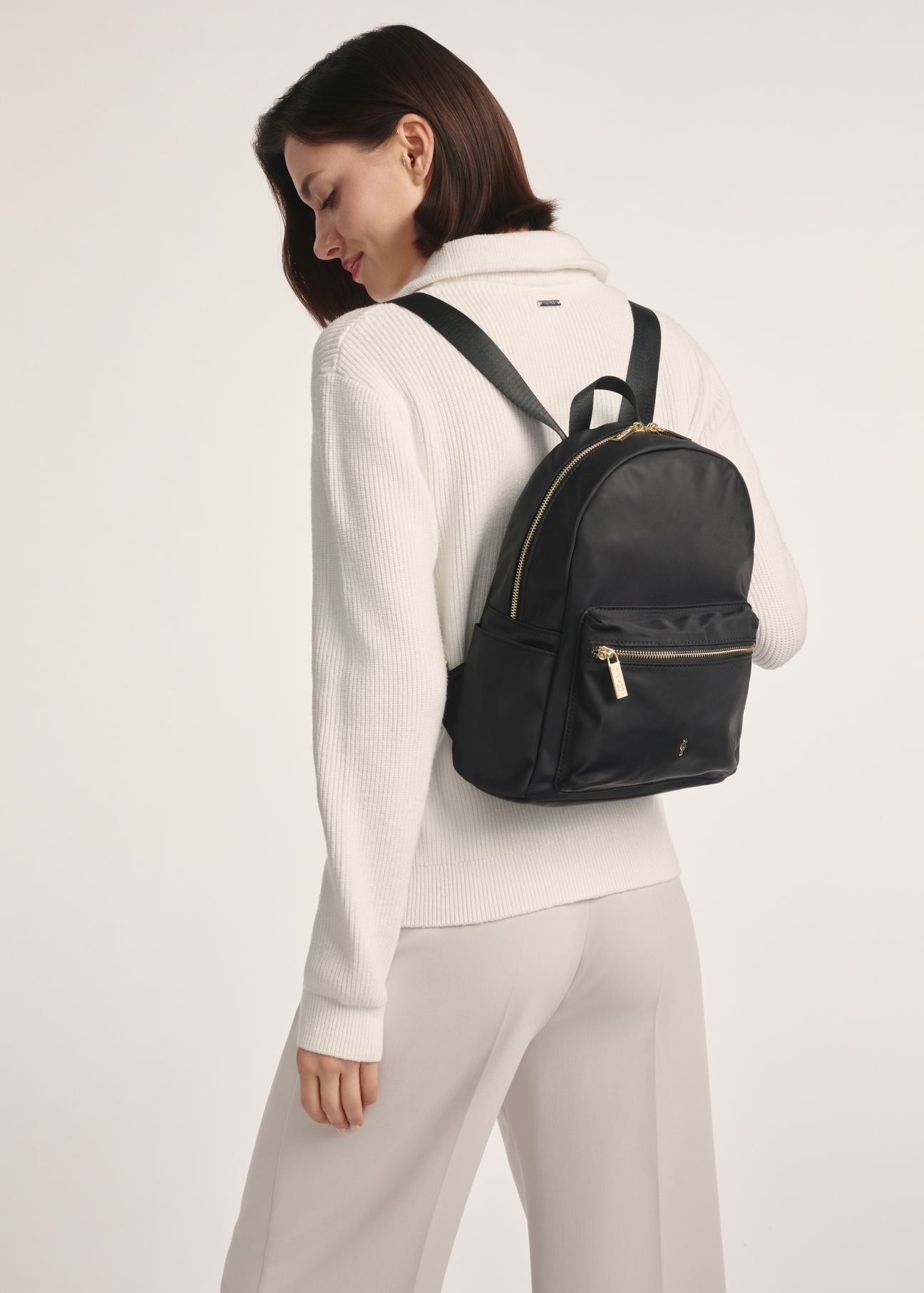 TOREN-0319-99 (Z25) women's compact backpack - front view of the product on a model against a white background. Full back view.