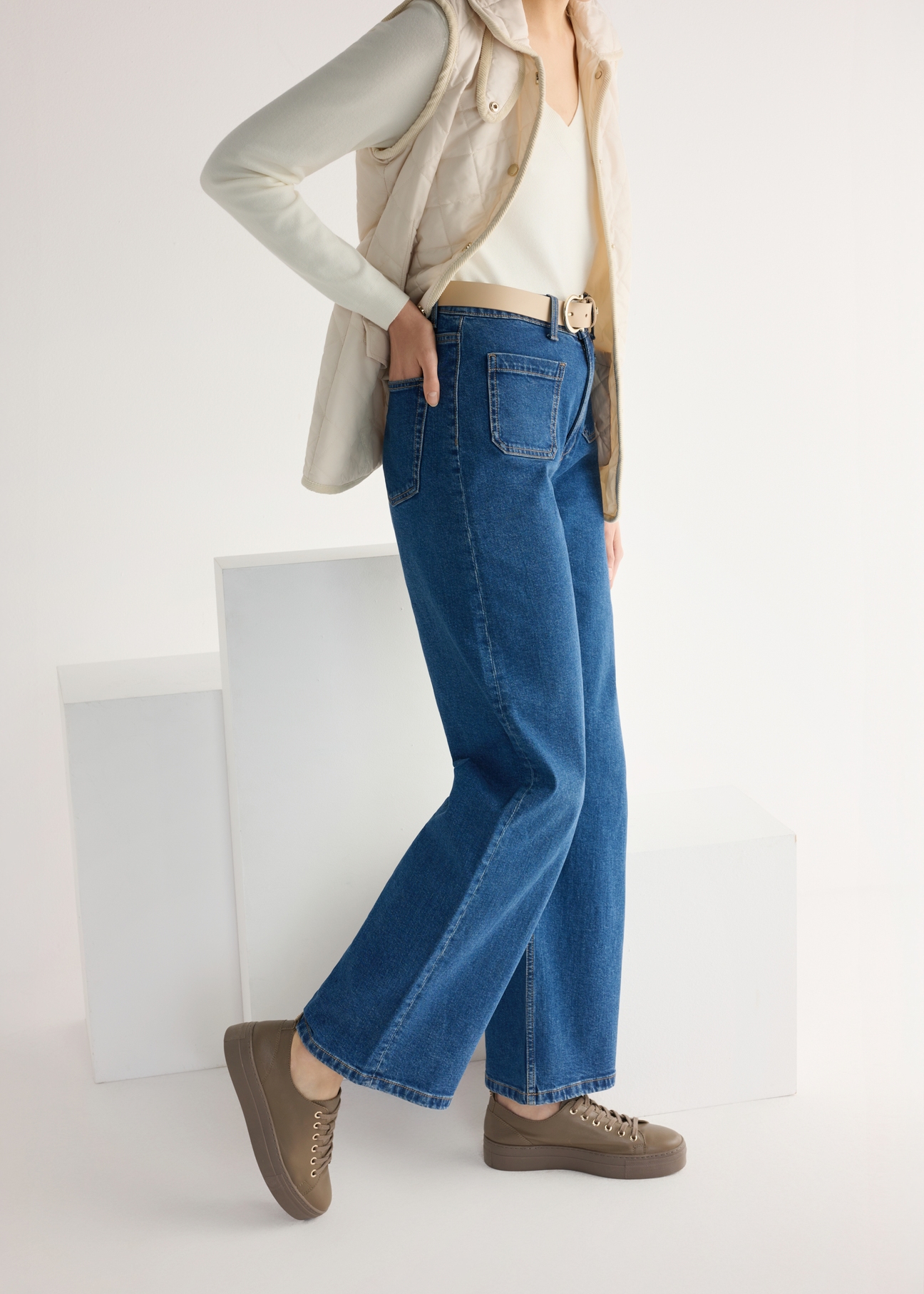 Women's leather sneakers in cool beige color BUTYD-1062-1K(W26), side view of the product on the model, half of the silhouette visible.