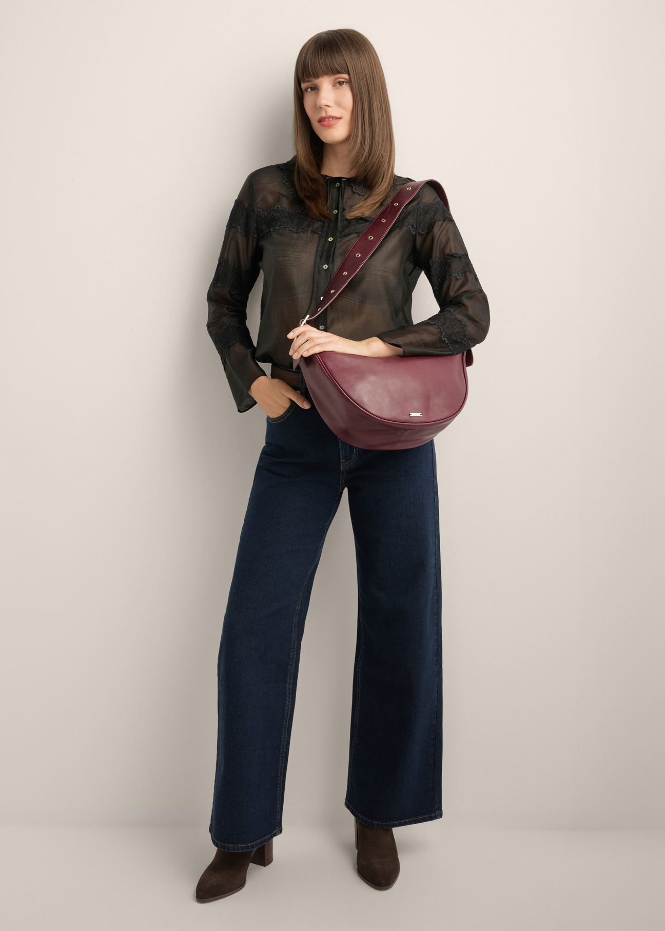 Burgundy semi-circular women's handbag TORES-1350-4D(Z26), front view of the product on the model's shoulder, on a light background.