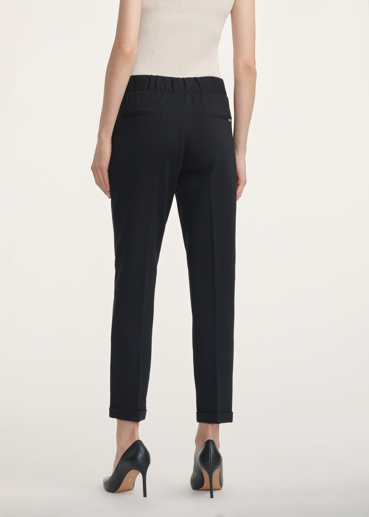 Black women's trousers with a crease SPODT-0098-99(Z24), view of the product from the back on the model, half of the silhouette visible.