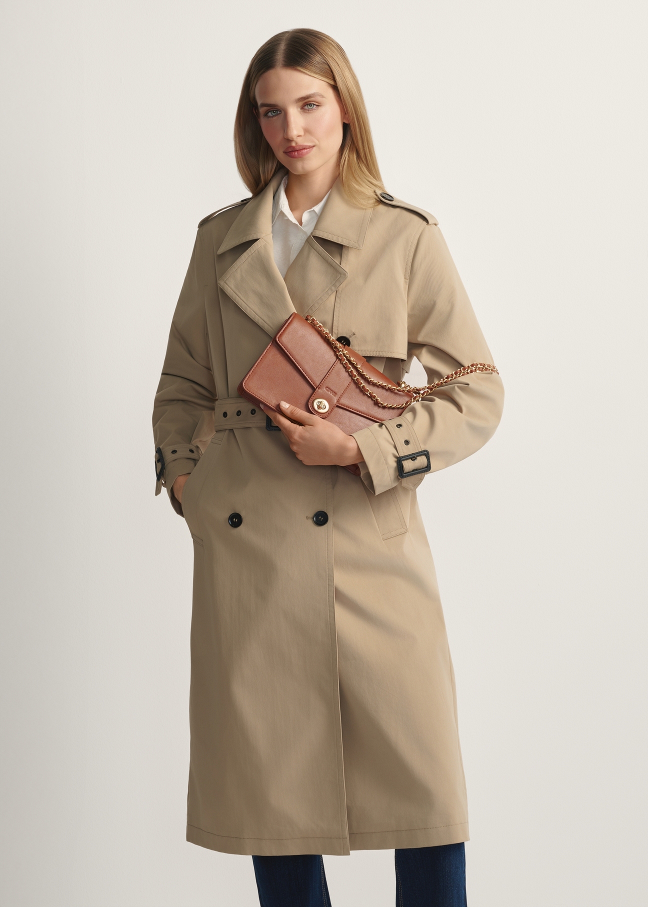 Women's brown messenger bag TOREC-1137-1F(W26) - front view of the product, on a model, against a light background. Knee-length silhouette visible.