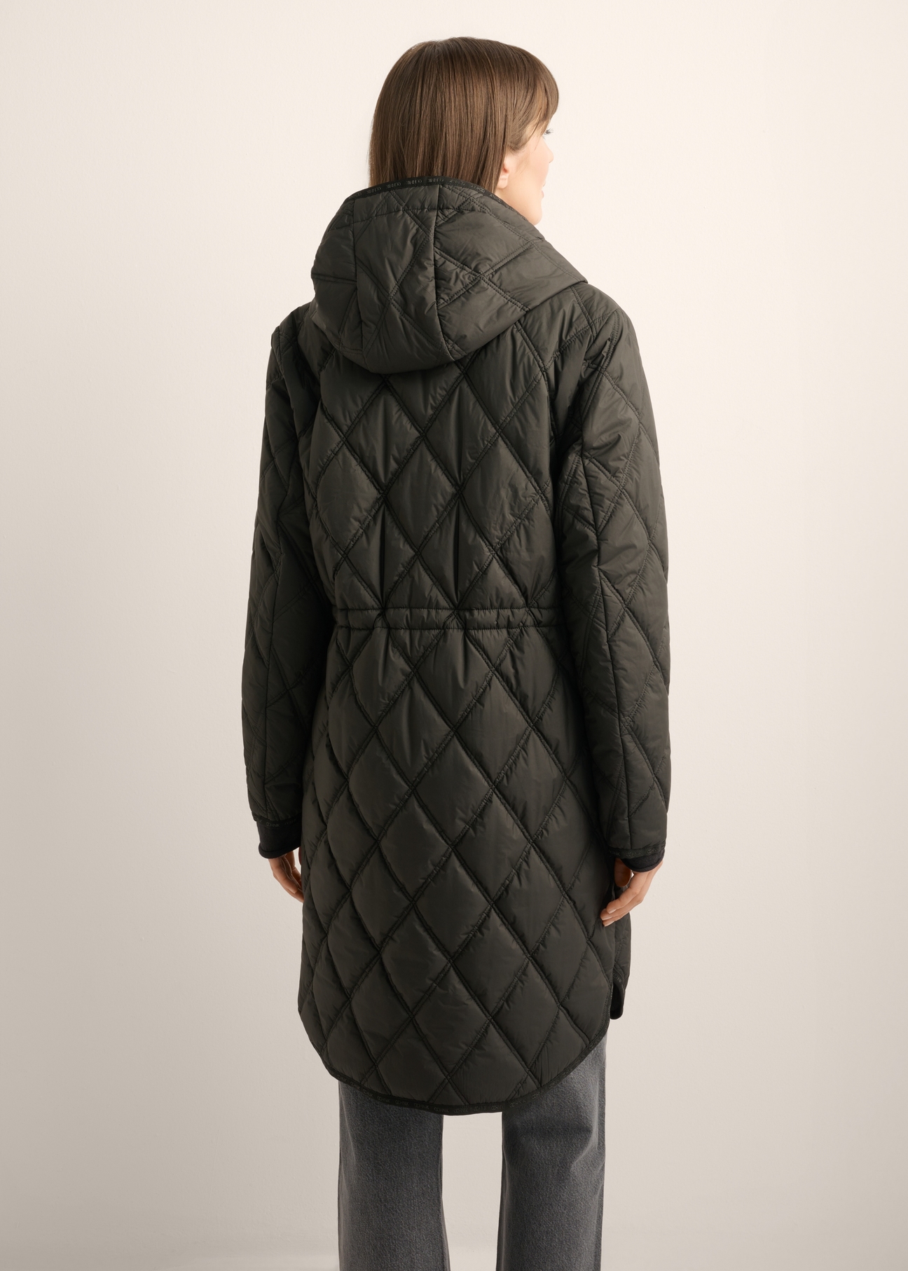 Women's black quilted jacket KURDT-0579-99(Z25), back view of the product on the model. Half of the silhouette visible.