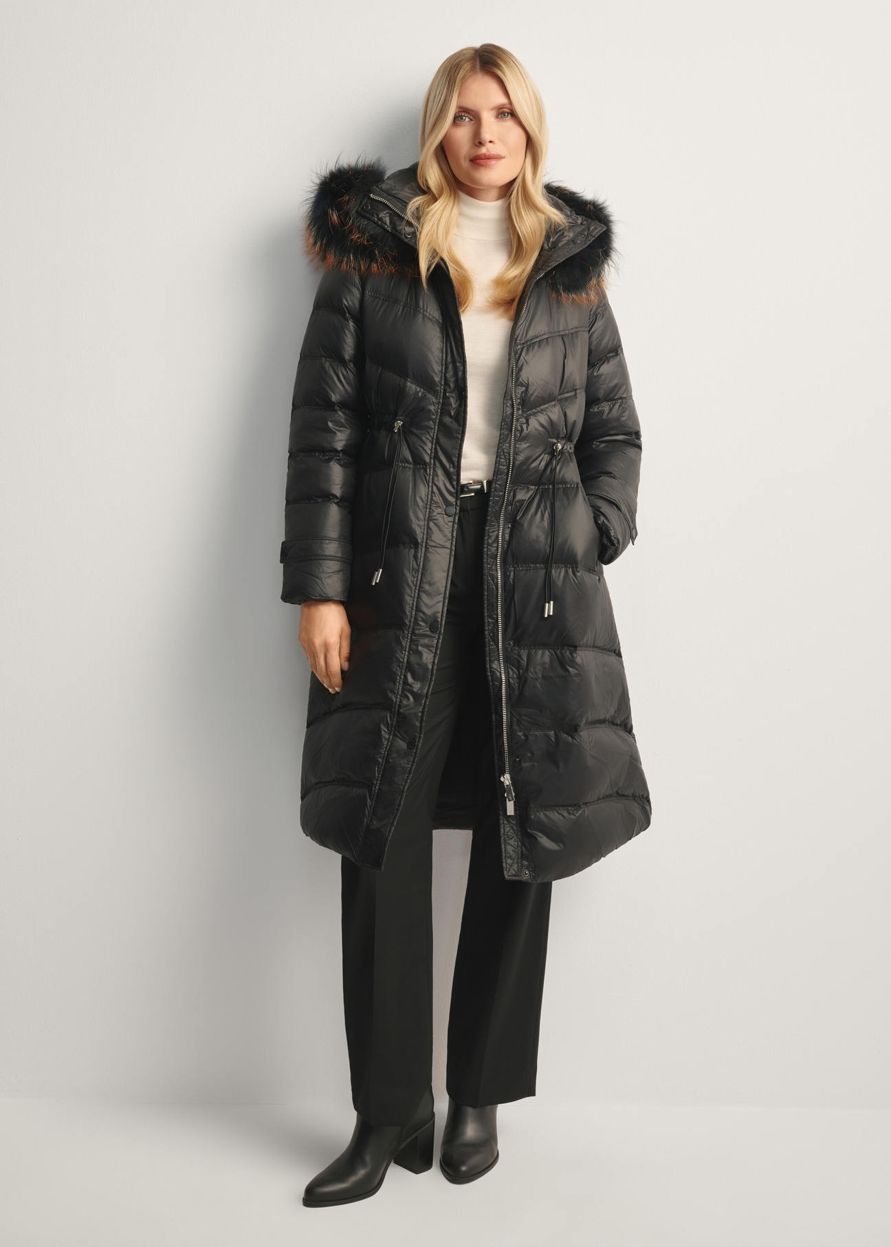 Black women's winter jacket with natural fur KURDT-0618-99(Z25), front view of the product on the model, the entire silhouette is visible.