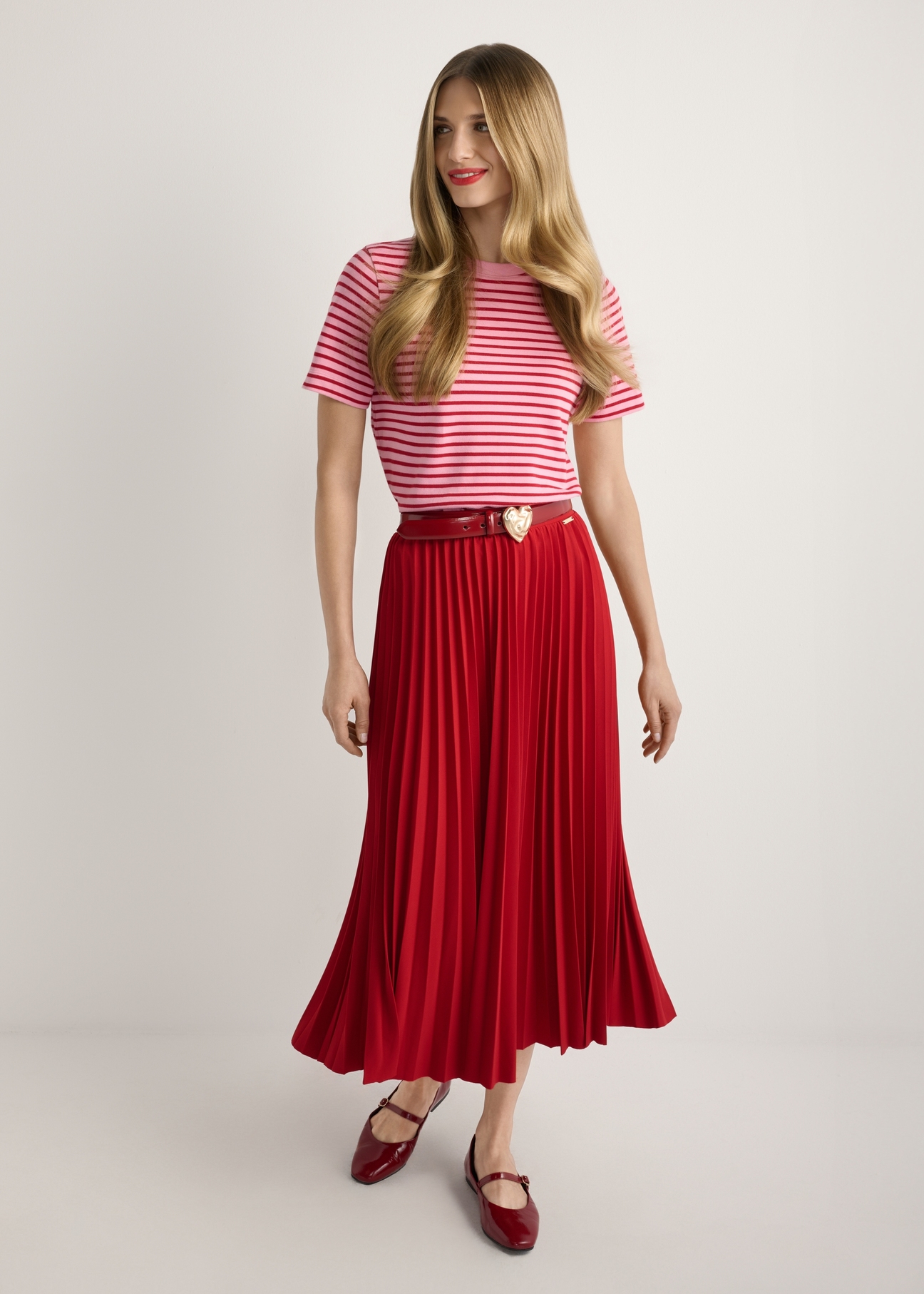 Red pleated midi skirt SPCDT-0096-4B(W26), product view from the front on the model, full silhouette visible.