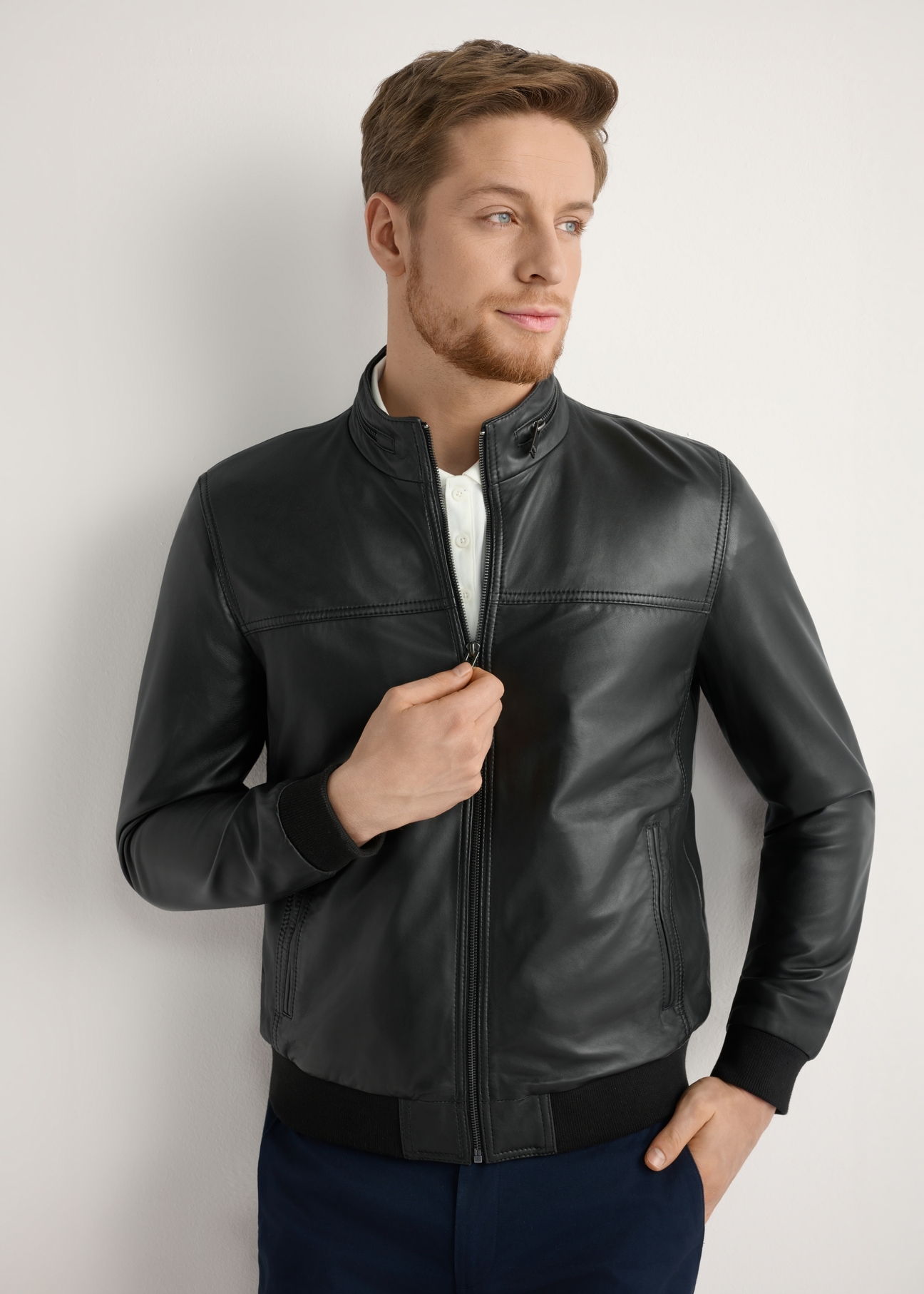 Men's black leather jacket KURMS-0392-99(W26) - front view of the product, on a model, against a light background. Half of the silhouette visible.