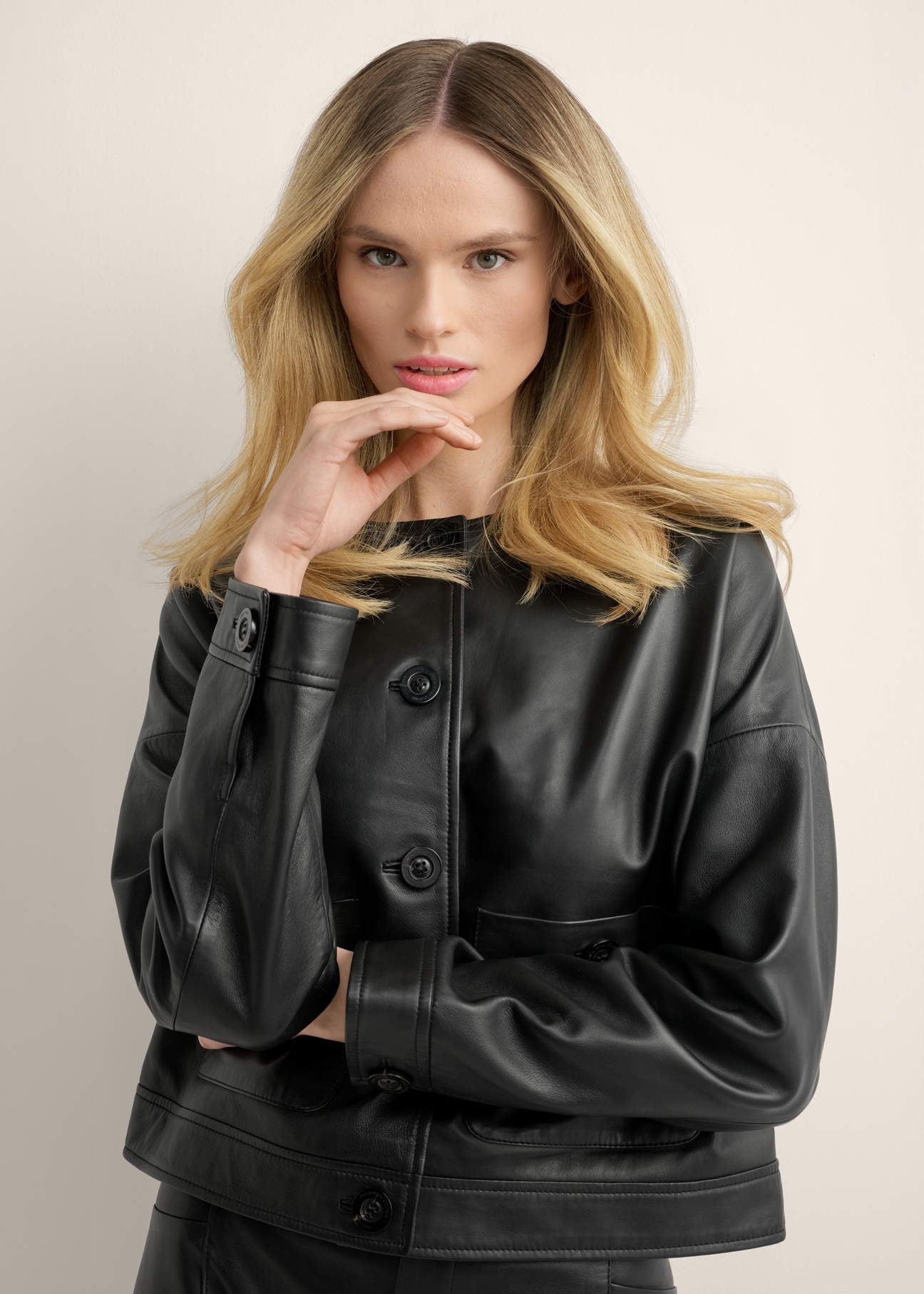 Short black women's leather jacket KURDS-0629-99(Z26), close-up of the product on the model's silhouette.