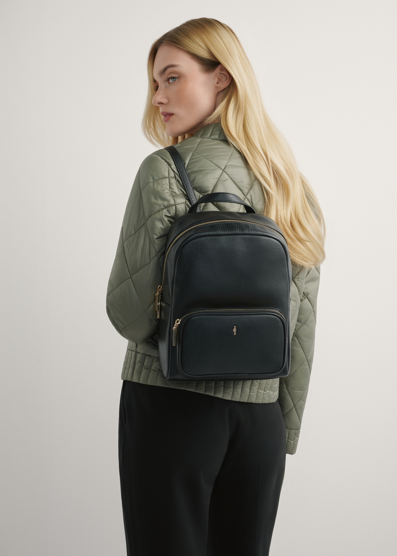 Black Leather women's backpack TORES-1072E-9I(W26), front view of the product on a model, half of the silhouette visible.